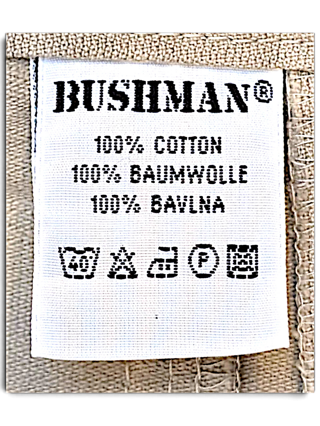JAKE & IPI Bushman utility trousers white fabric care label showing 100 percent cotton composition and wash symbols
