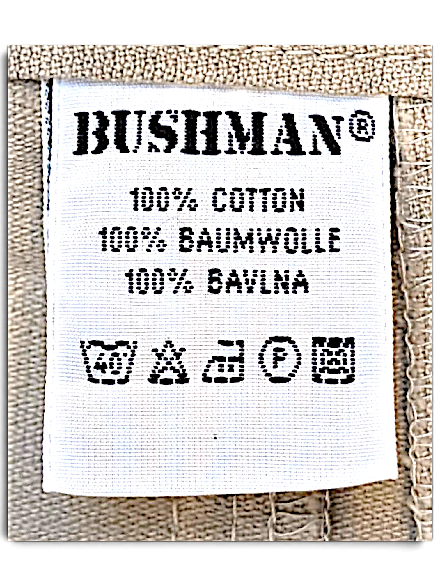 JAKE & IPI Bushman utility trousers white fabric care label showing 100 percent cotton composition and wash symbols