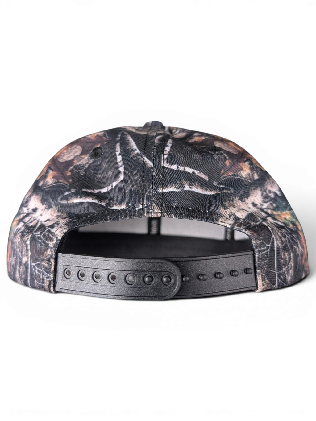 JAKE & IPI IBE Elenyor cap featuring a woodland camouflage pattern and an adjustable black plastic snapback closure.