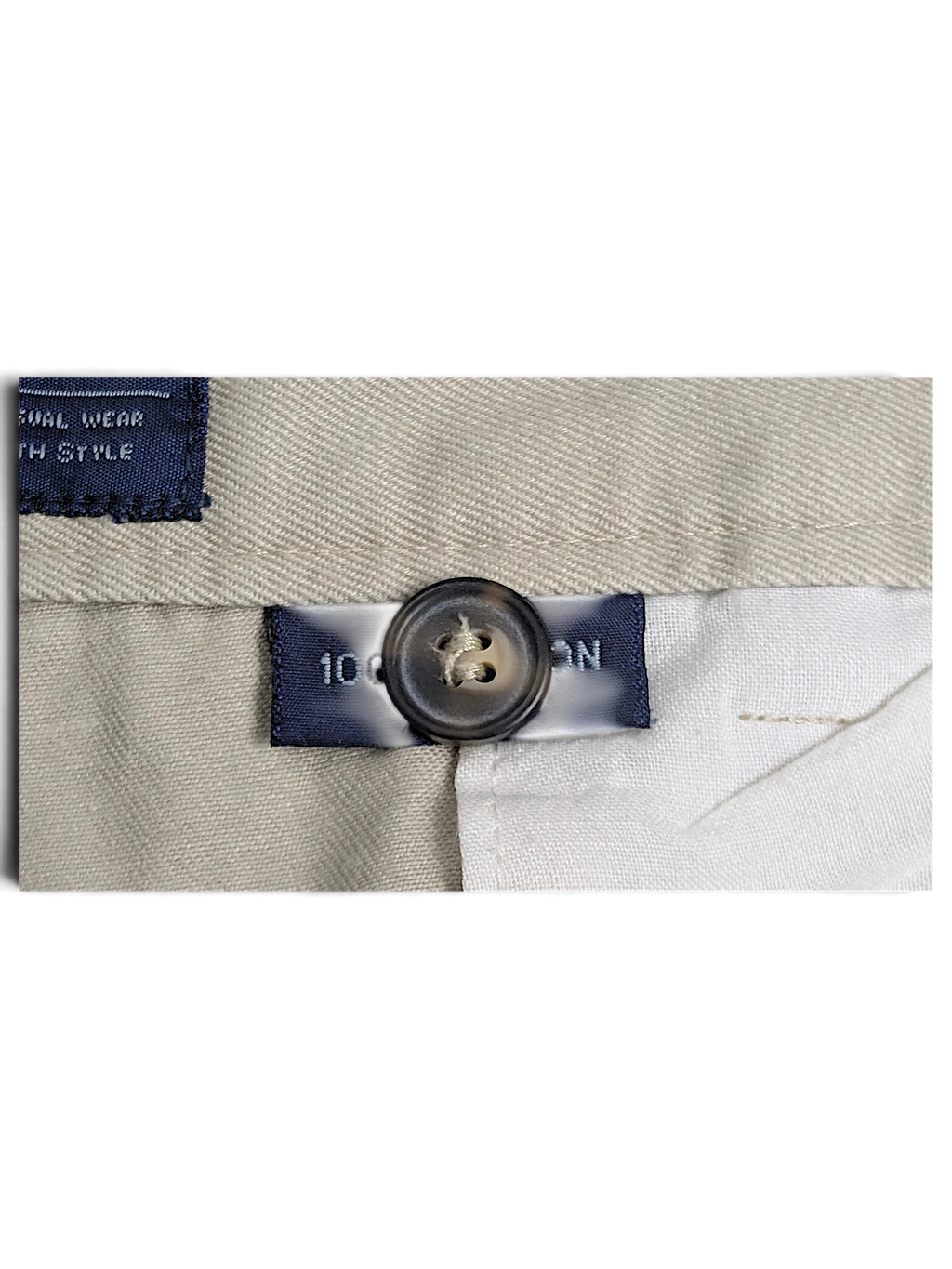 JAKE & IPI Cedarwood State beige cotton trousers detail showing the button and fabric composition label