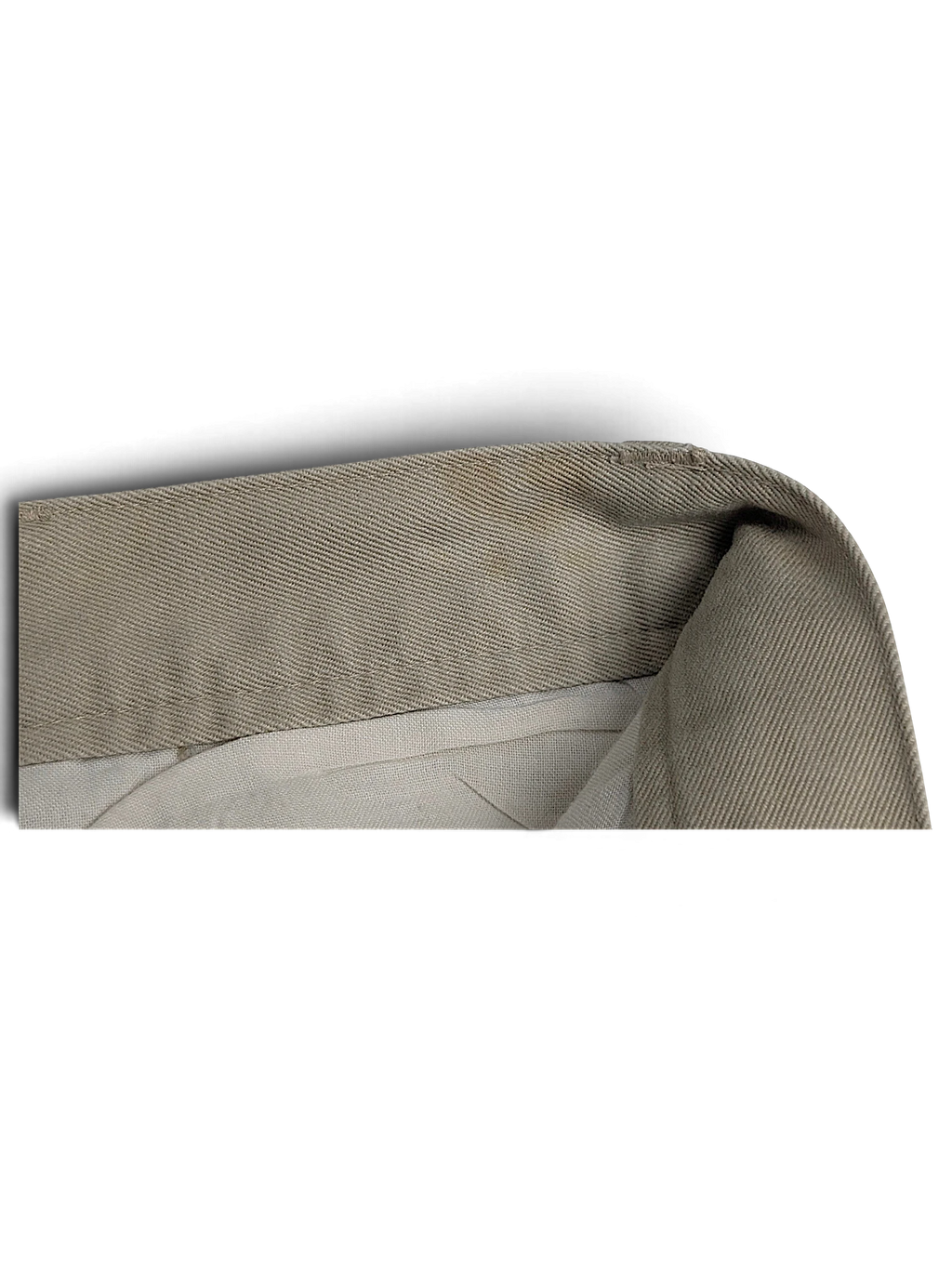 Close-up of the beige cotton fabric and waistband construction of JAKE & IPI Cedarwood State pleated trousers.