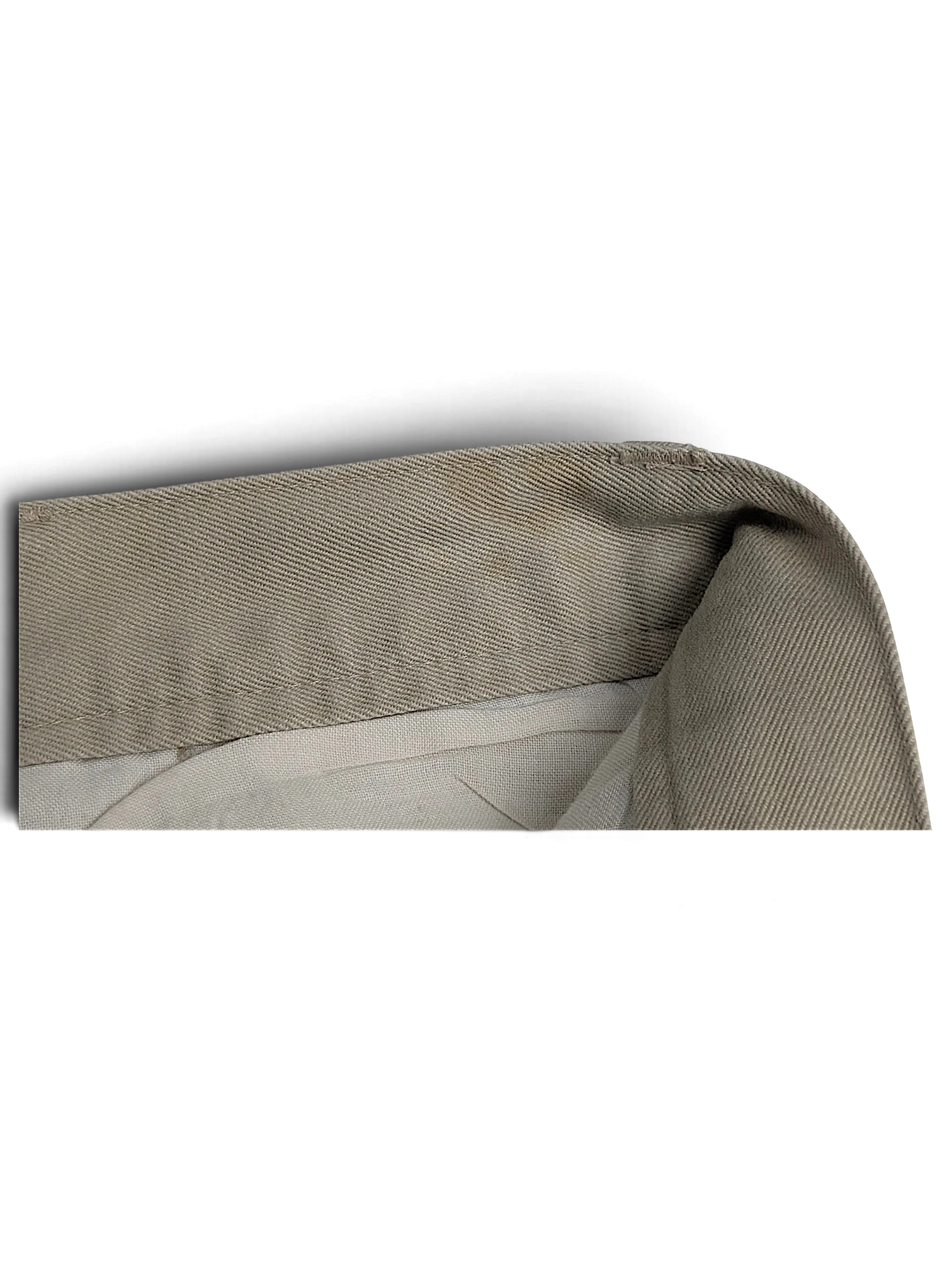 Close-up of the beige cotton fabric and waistband construction of JAKE & IPI Cedarwood State pleated trousers.