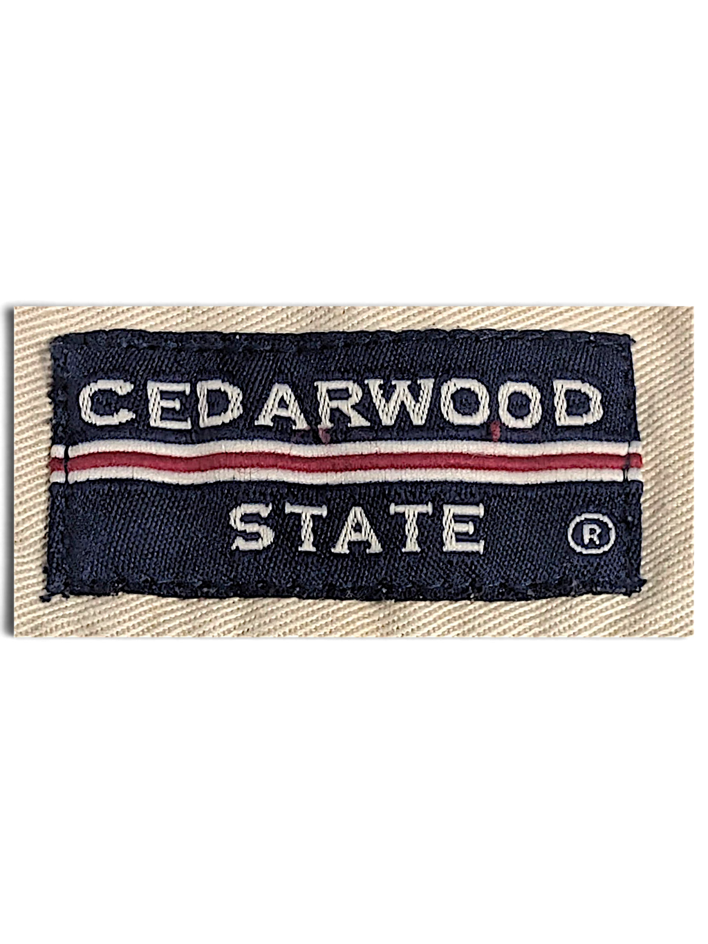 JAKE & IPI Cedarwood State navy blue and red woven brand label on beige cotton fabric