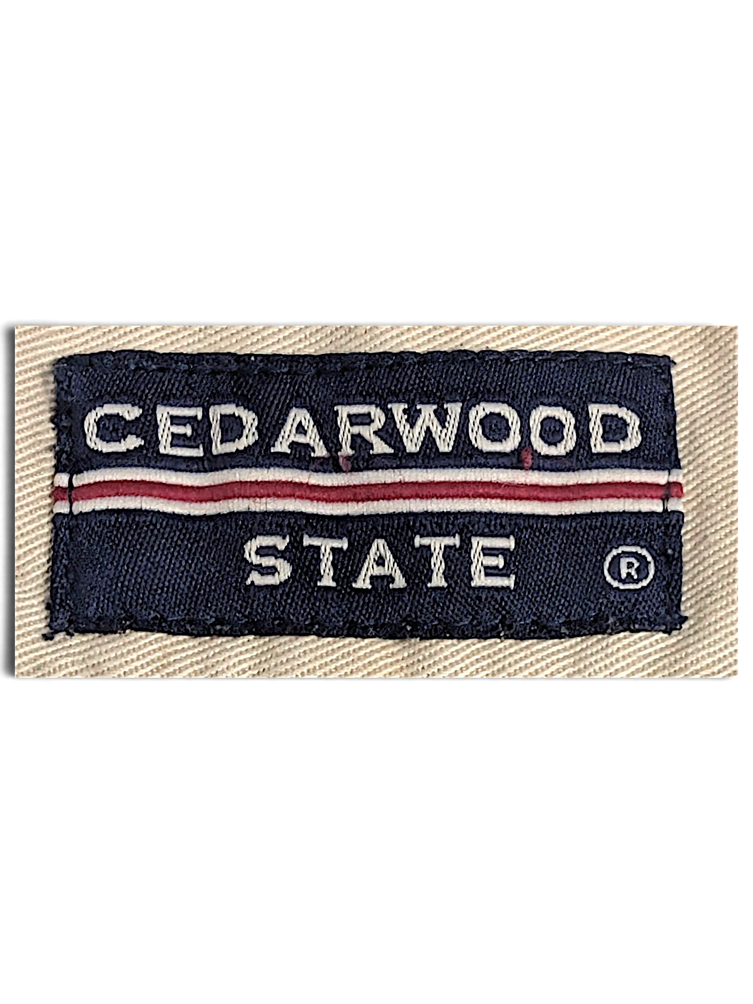 JAKE & IPI Cedarwood State navy blue and red woven brand label on beige cotton fabric
