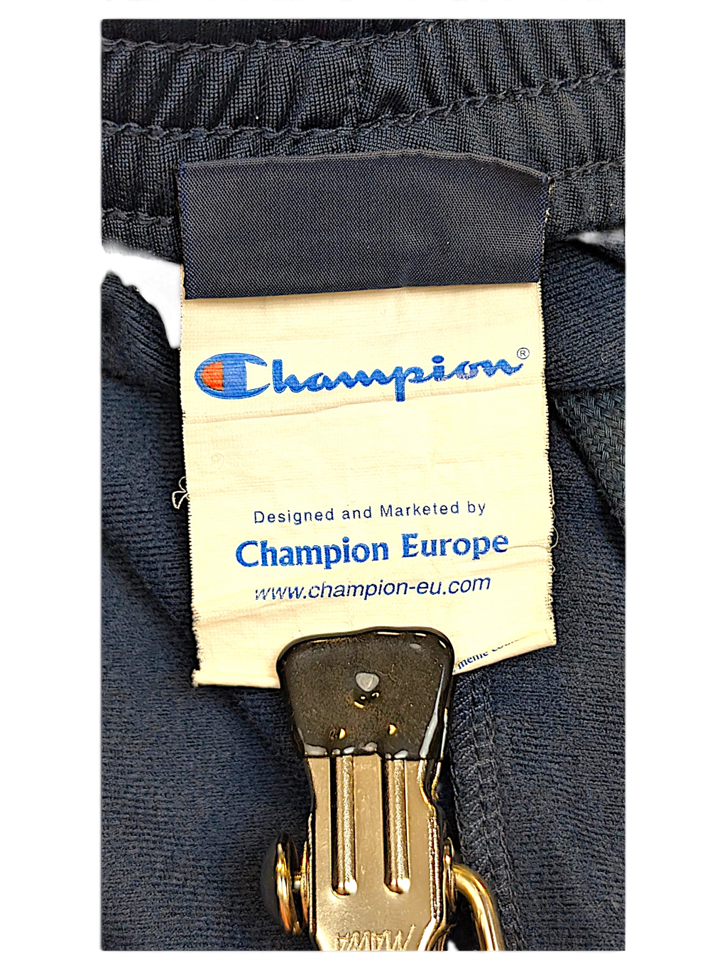 JAKE & IPI Champion brand label on navy track pants with Champion Europe text and logo