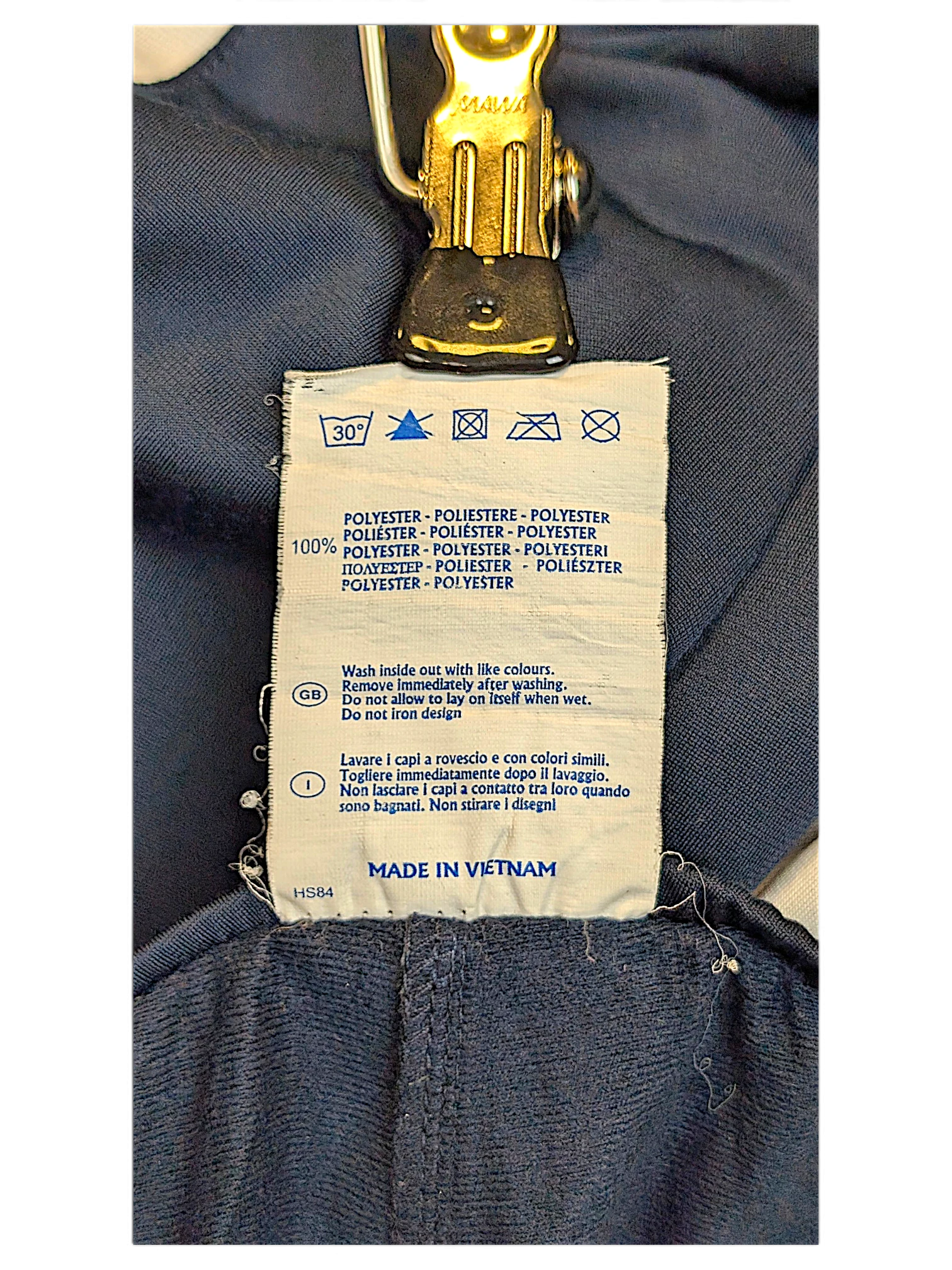 JAKE & IPI Champion track pants care label showing 100% polyester composition and care instructions