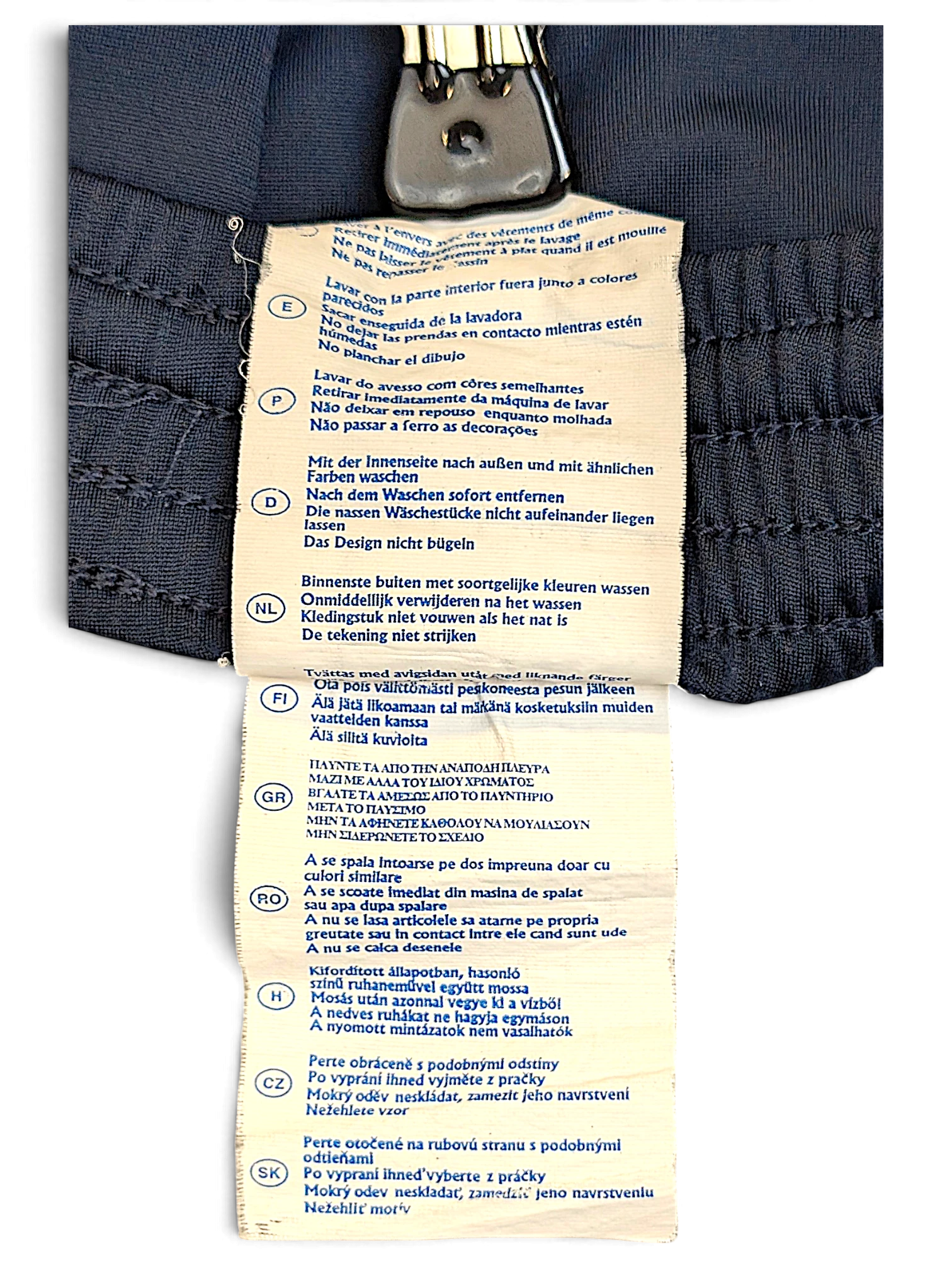 JAKE & IPI Champion track pants care label with multi-language washing instructions on navy fabric