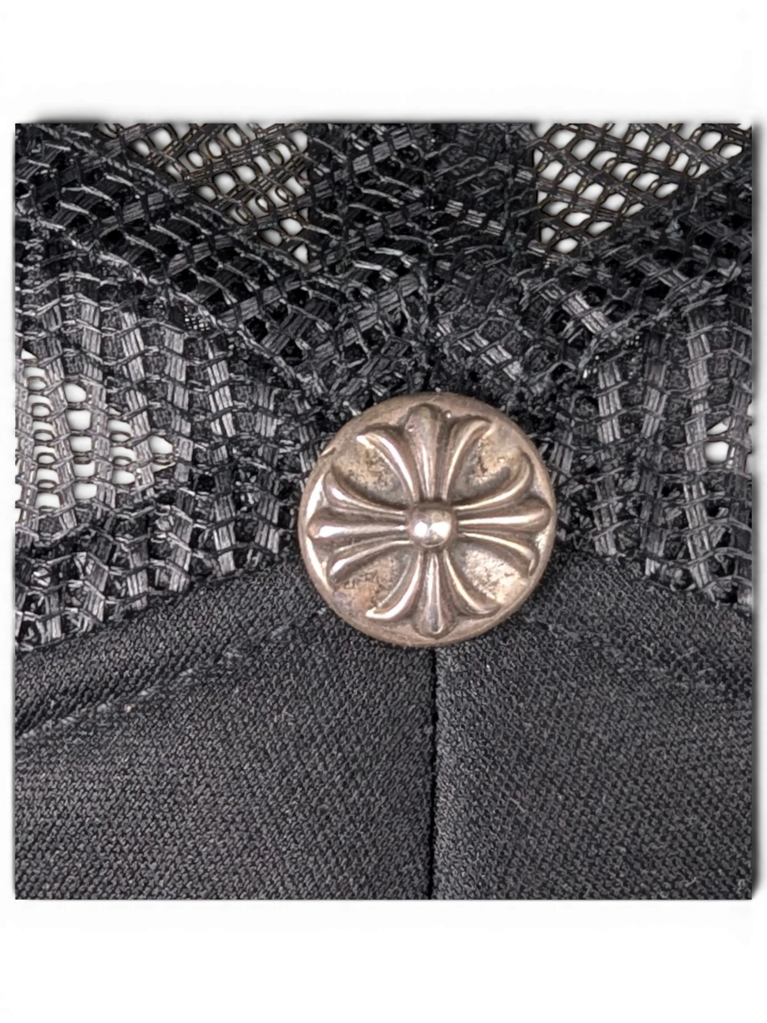 JAKE & IPI black trucker hat featuring a silver Chrome Hearts cross button detail on the mesh crown