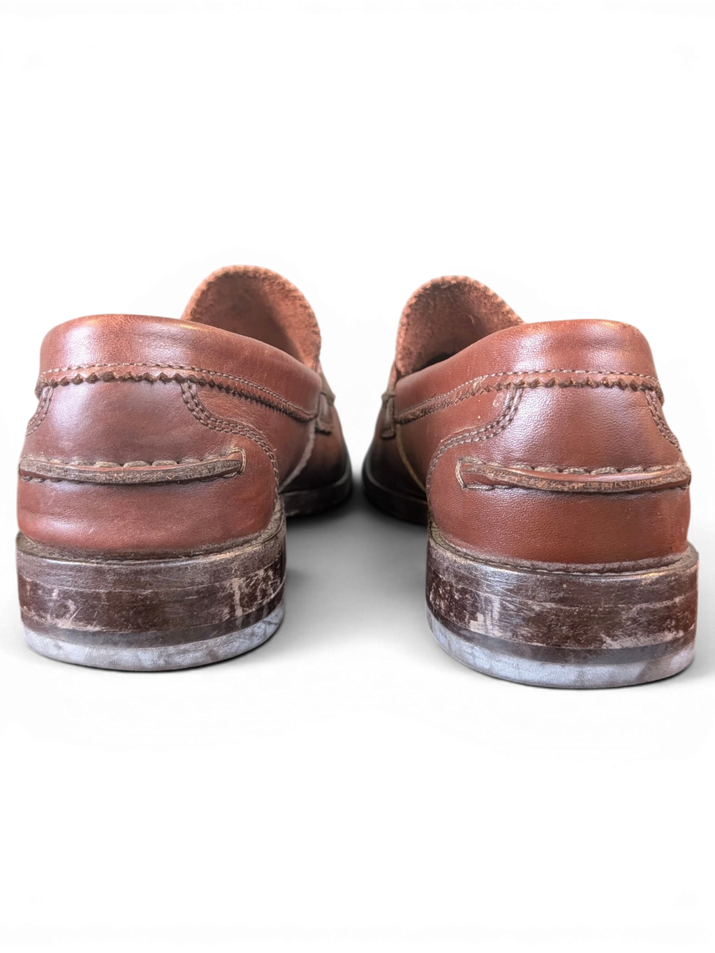 JAKE & IPI Clarks brown leather penny loafers, back view showing stitched heel detail and worn soles.