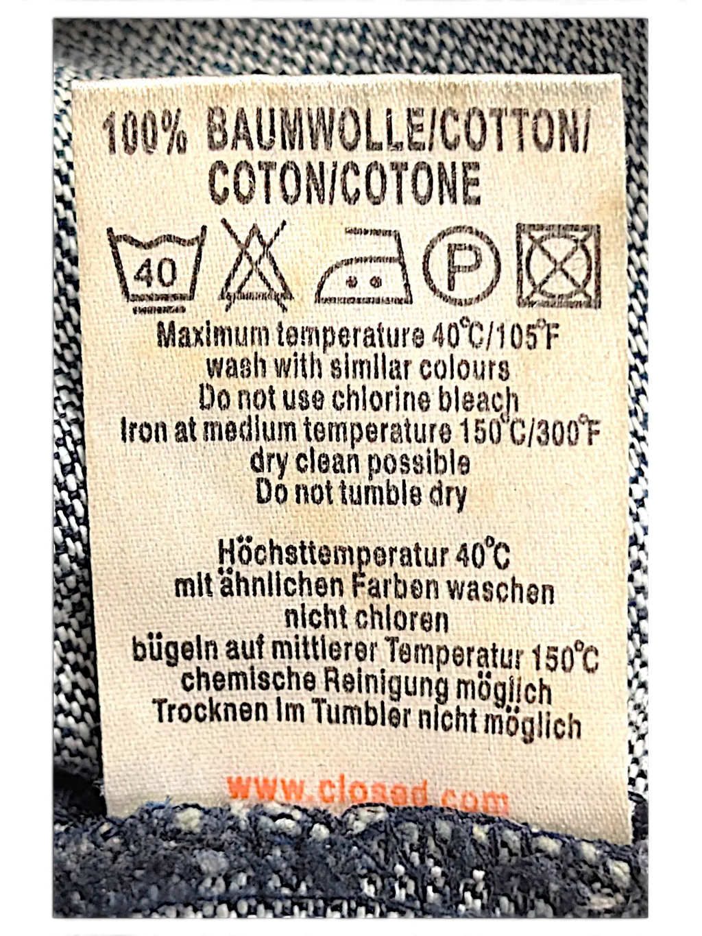 JAKE & IPI Closed jeans care label showing 100% cotton material and washing instructions on blue denim fabric