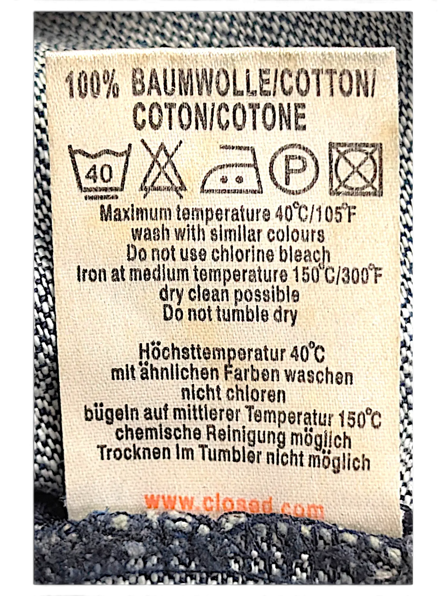 JAKE & IPI Closed jeans care label showing 100% cotton material and washing instructions on blue denim fabric