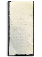 JAKE & IPI Converse Cropped College garment care label with washing instructions and symbols on a dark fabric background