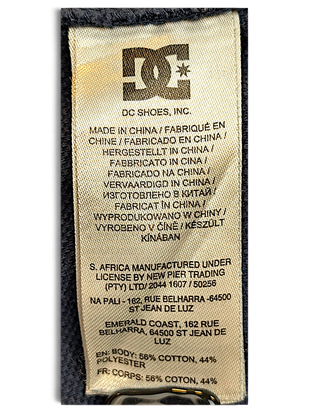 JAKE & IPI DC track pants care label showing fabric composition of 56 percent cotton and 44 percent polyester