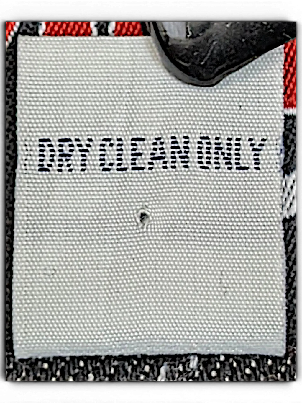JAKE & IPI VIBES denim jacket white fabric care label with black text reading DRY CLEAN ONLY held by a metal clip