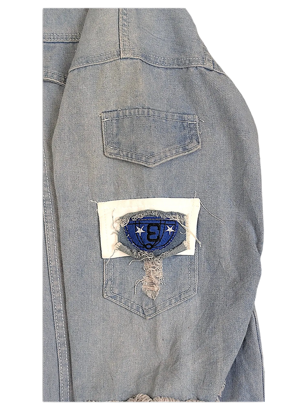 JAKE & IPI light wash denim jacket sleeve featuring a distressed white patch with a blue embroidered logo detail
