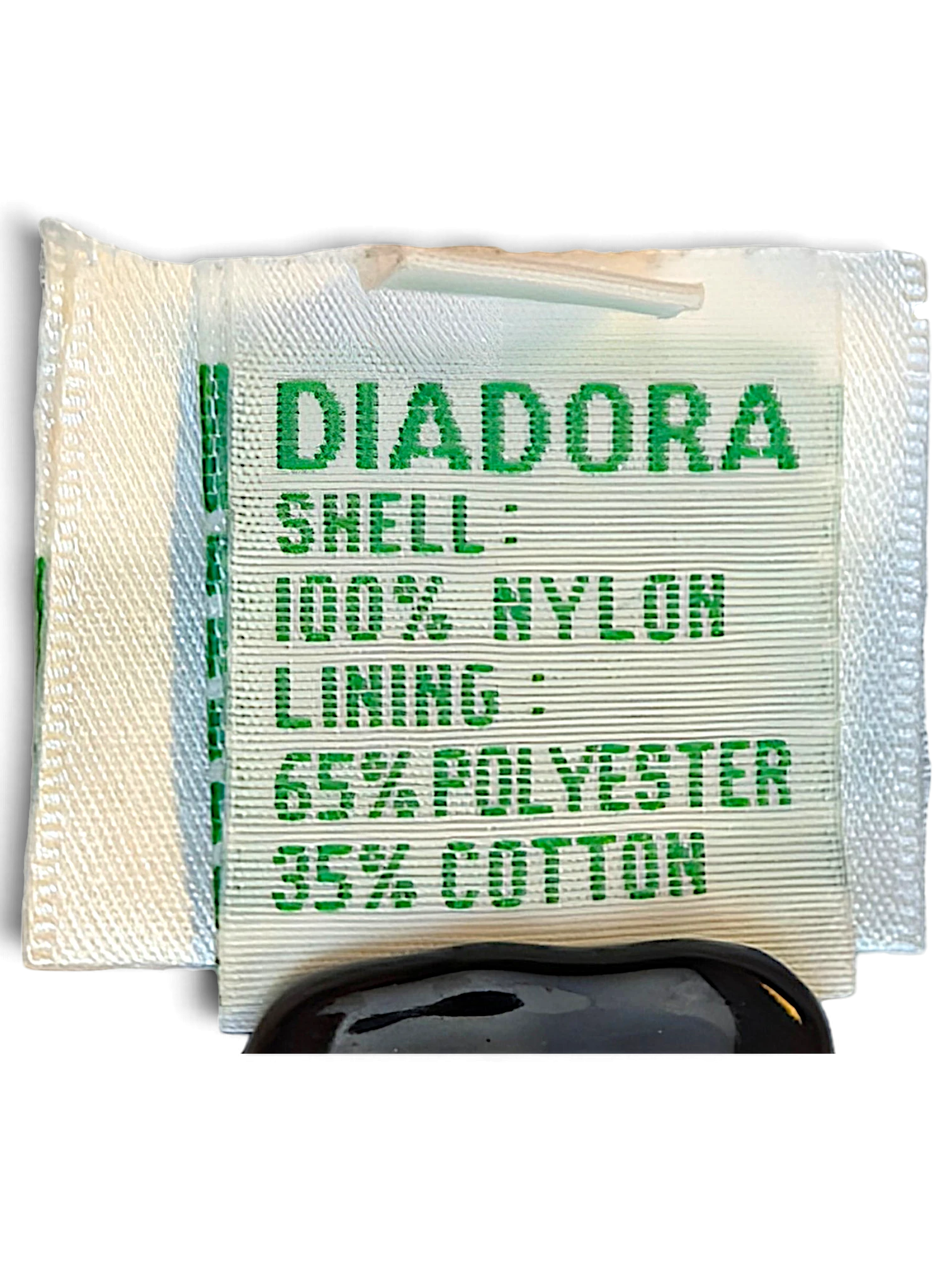 JAKE & IPI Diadora track pants fabric care label showing 100% nylon shell and polyester cotton lining composition