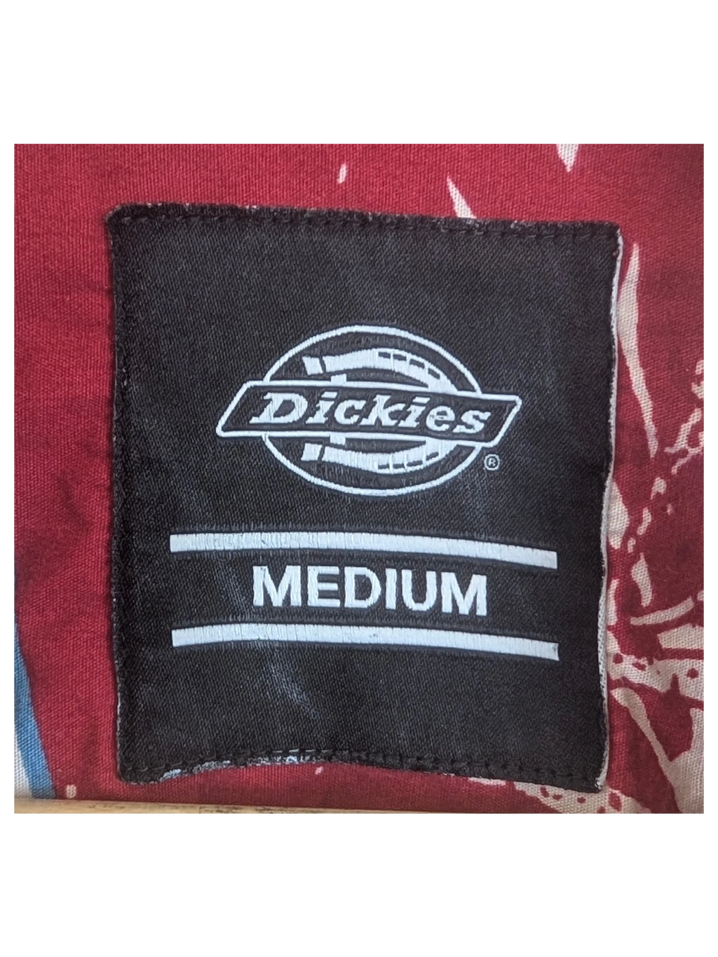 JAKE & IPI Dickies Hawaiian shirt in red with a floral pattern and a medium size neck label on a wooden hanger