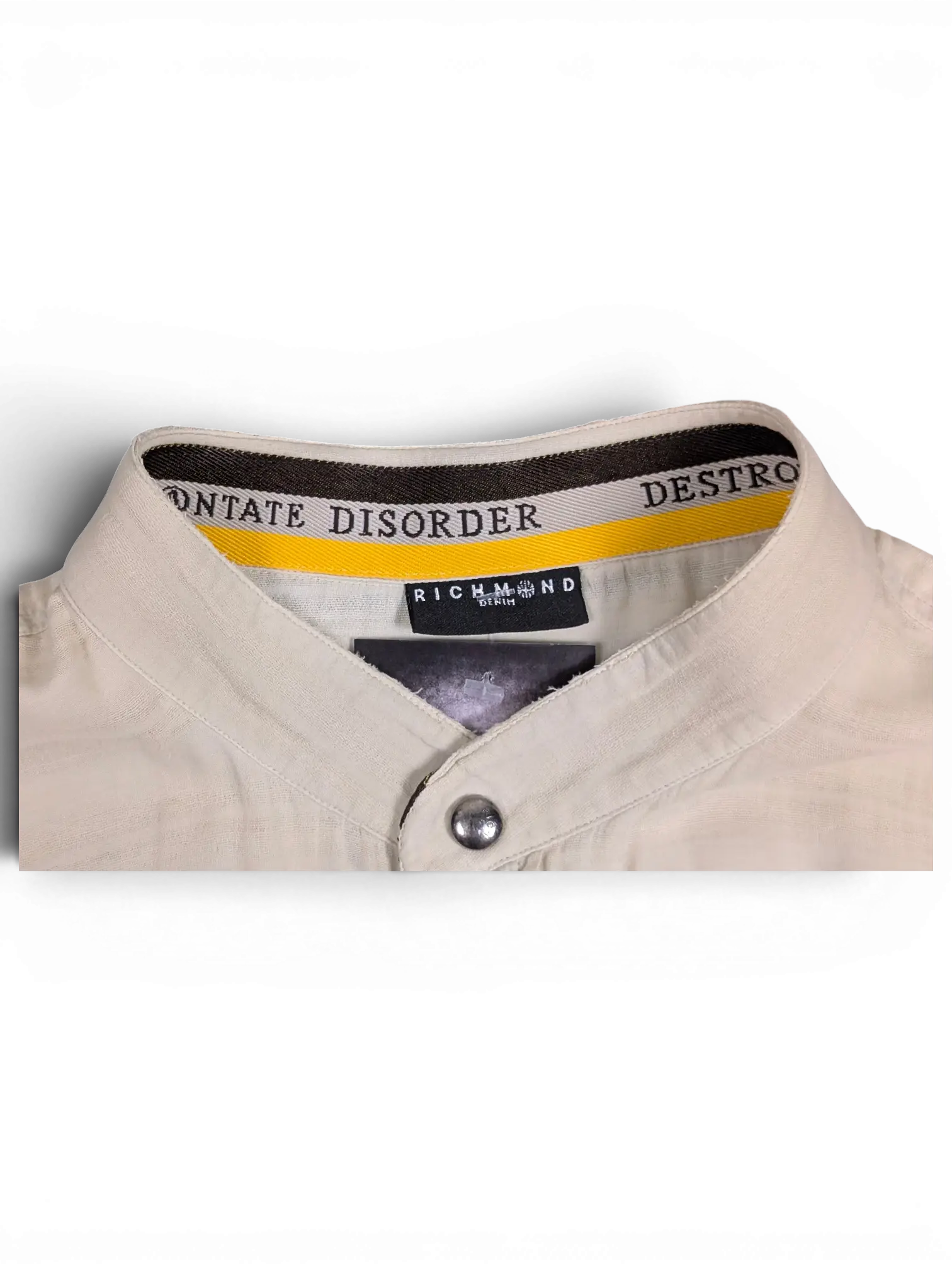 JAKE & IPI beige Disorder Richmond utility shirt featuring a stand collar with branded interior trim and snap buttons