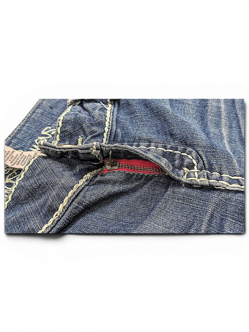 JAKE & IPI Almost Famous distressed blue denim jeans featuring thick white contrast stitching and a pink zipper detail.