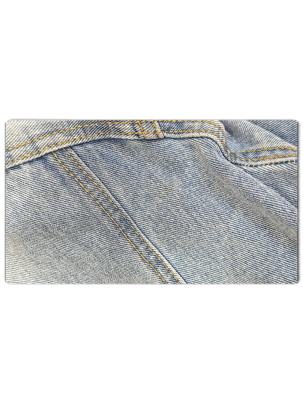 Close-up of JAKE & IPI light blue distressed denim jacket fabric with contrast yellow stitching