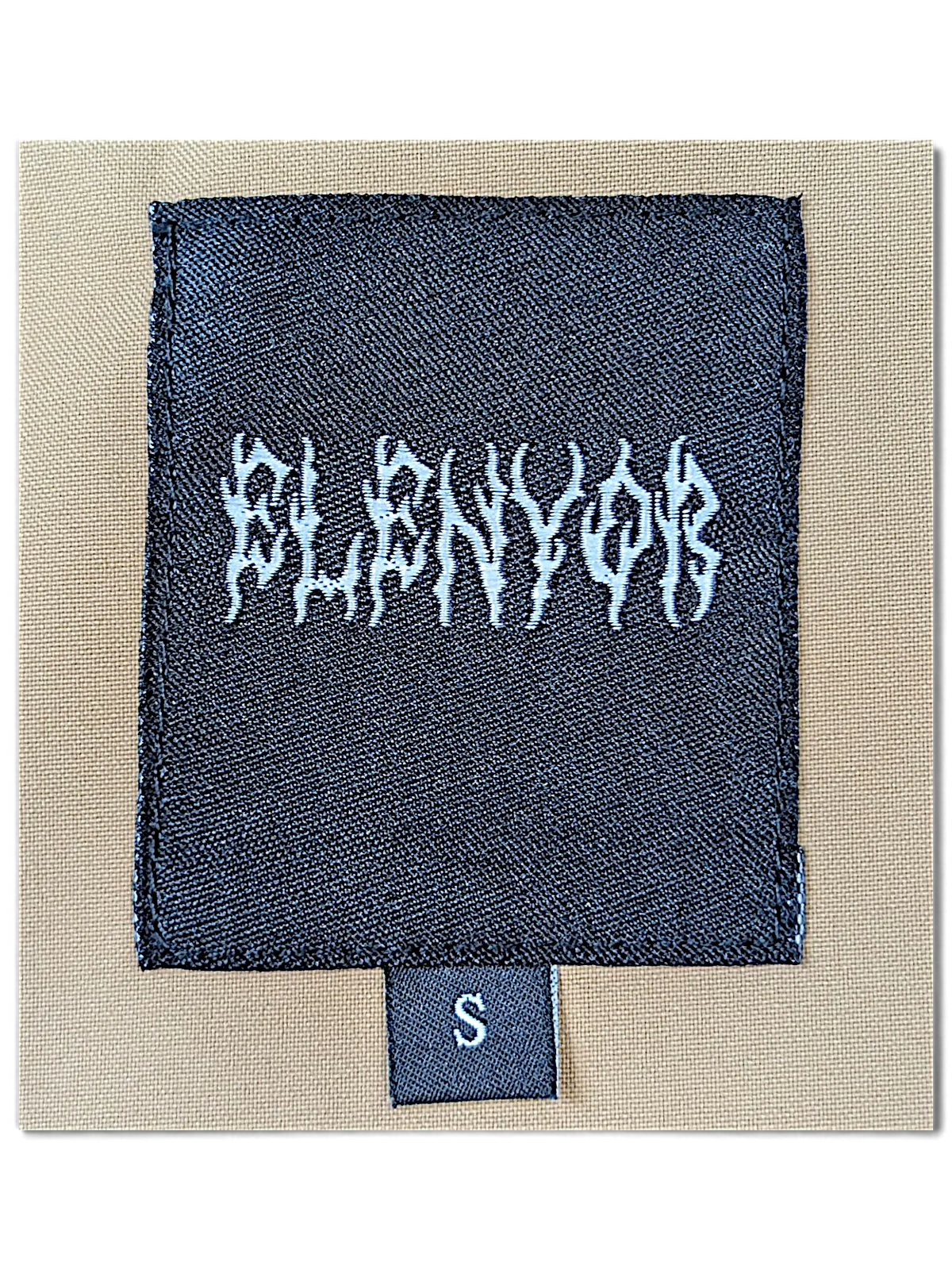 JAKE & IPI Elenyor brown jacket and pants clothing label with white gothic-style text on a black woven tag