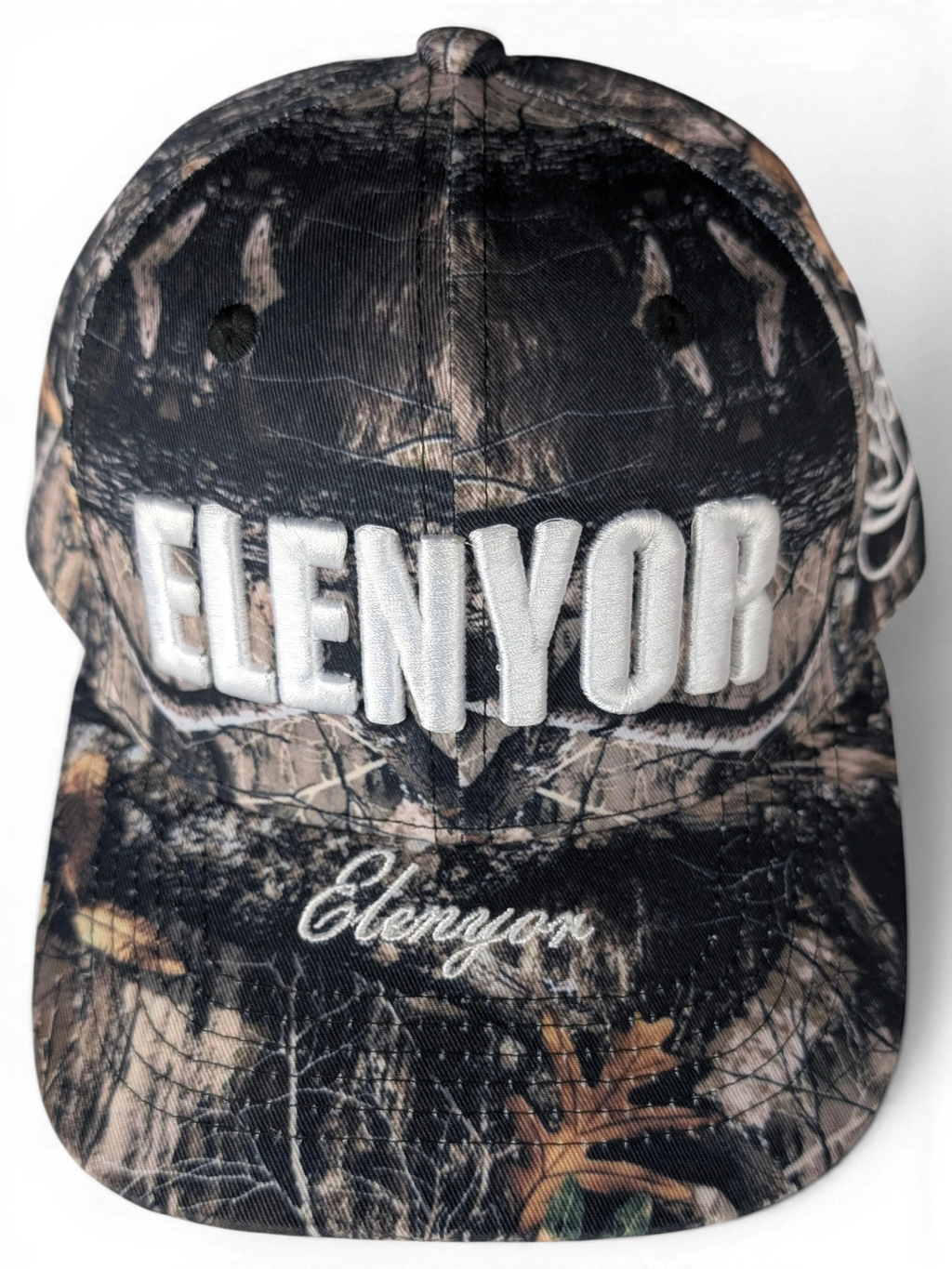 JAKE & IPI Elenyor baseball cap in a woodland camouflage print with white embroidered lettering on the front.