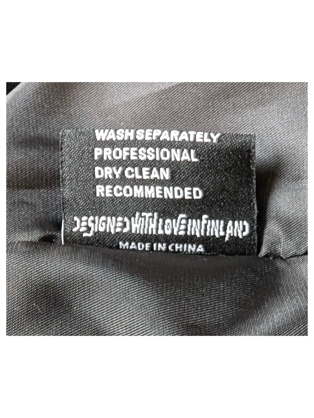 JAKE & IPI Elenyor jacket interior care label with washing instructions and Designed with Love in Finland text