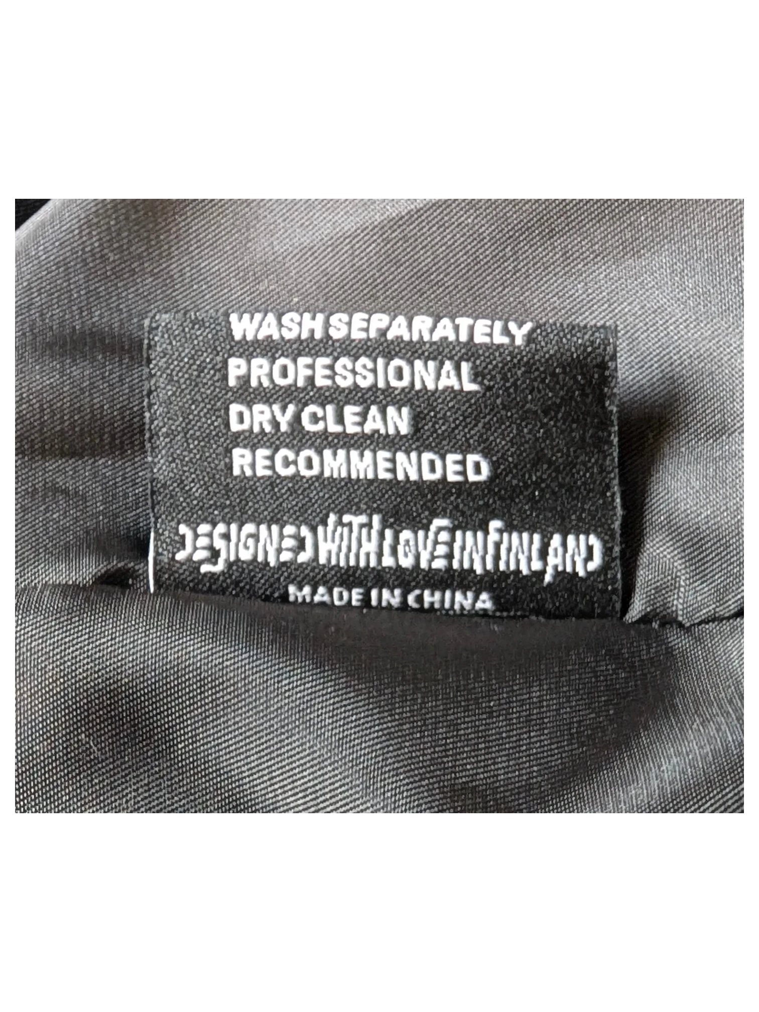 JAKE & IPI Elenyor jacket interior care label with washing instructions and Designed with Love in Finland text