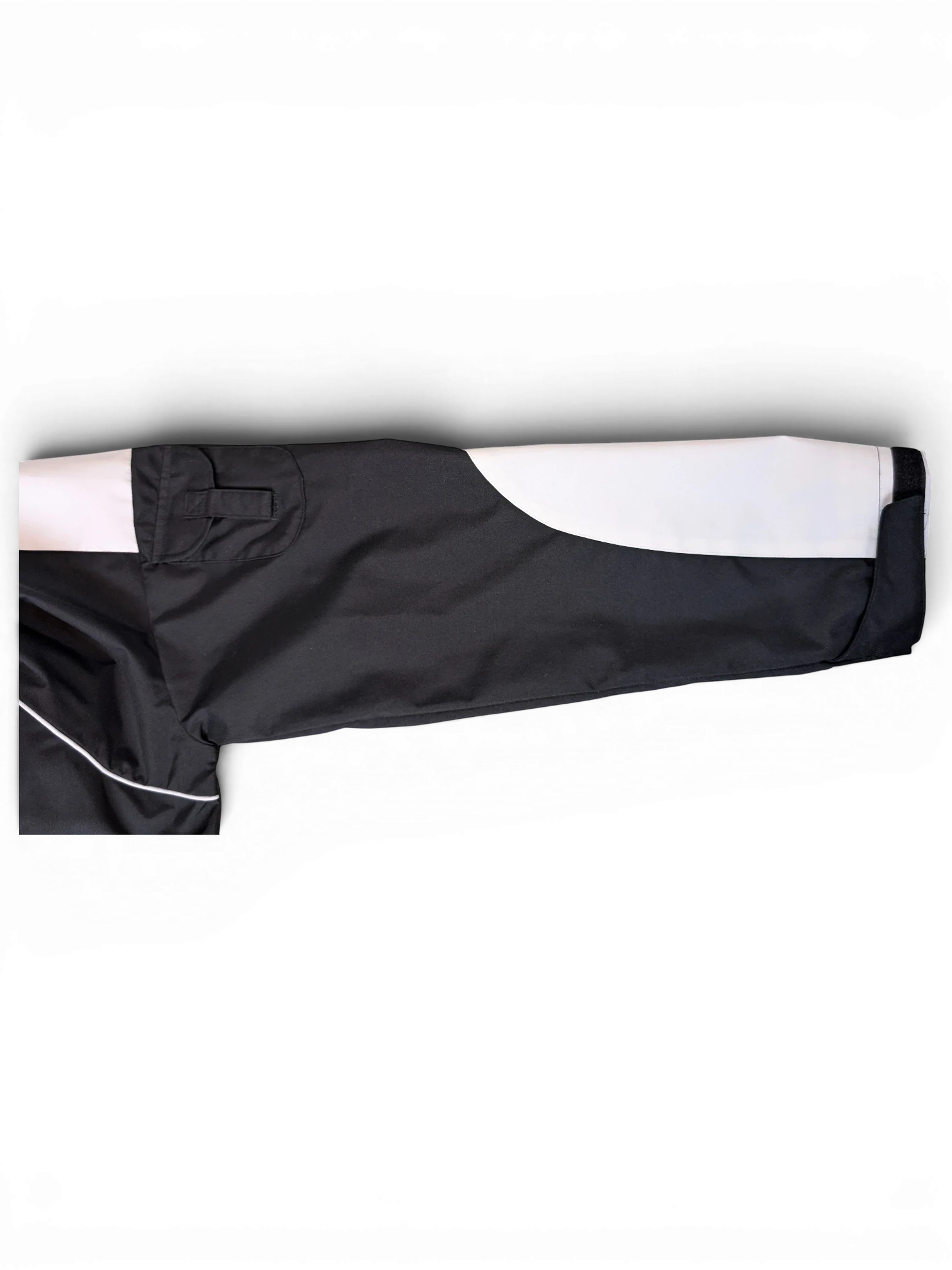 JAKE & IPI IBE Elenyor jacket sleeve featuring black and white color-blocked design with reflective piping detail.