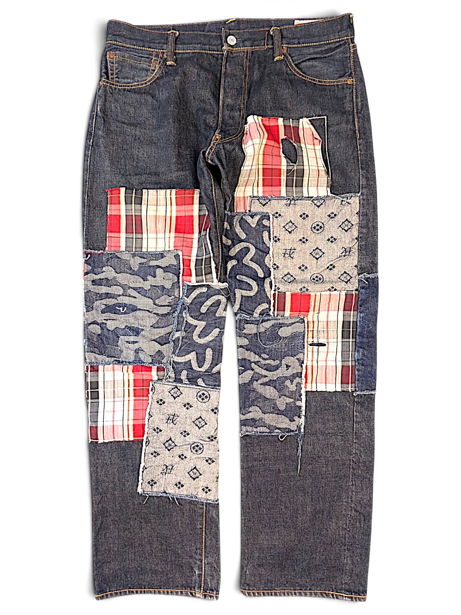 JAKE & IPI Evisu One Of One jeans featuring dark denim with mixed fabric patchwork, plaid, camo, and logo patterns.