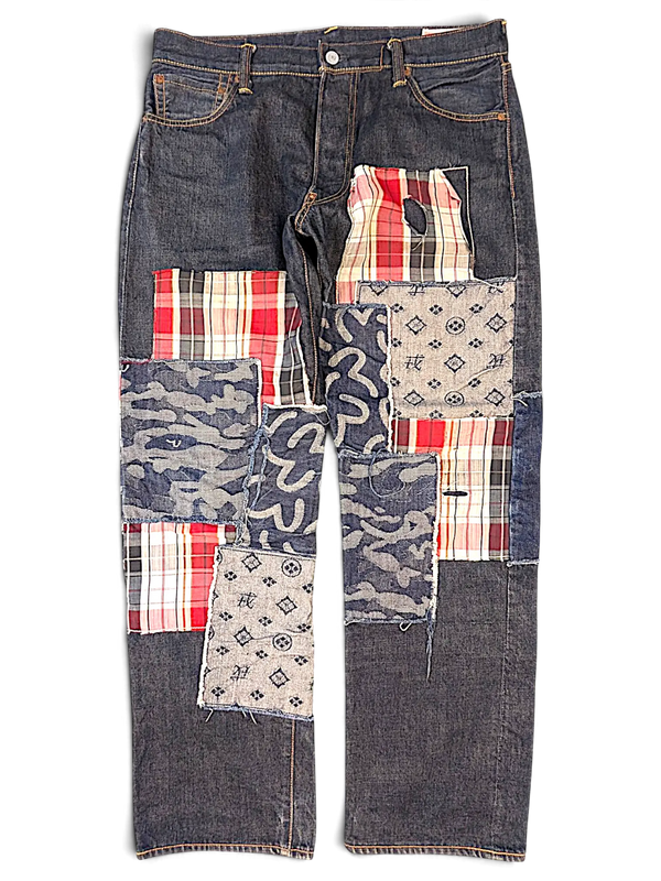 JAKE & IPI Evisu One Of One jeans featuring dark denim with mixed fabric patchwork, plaid, camo, and logo patterns.