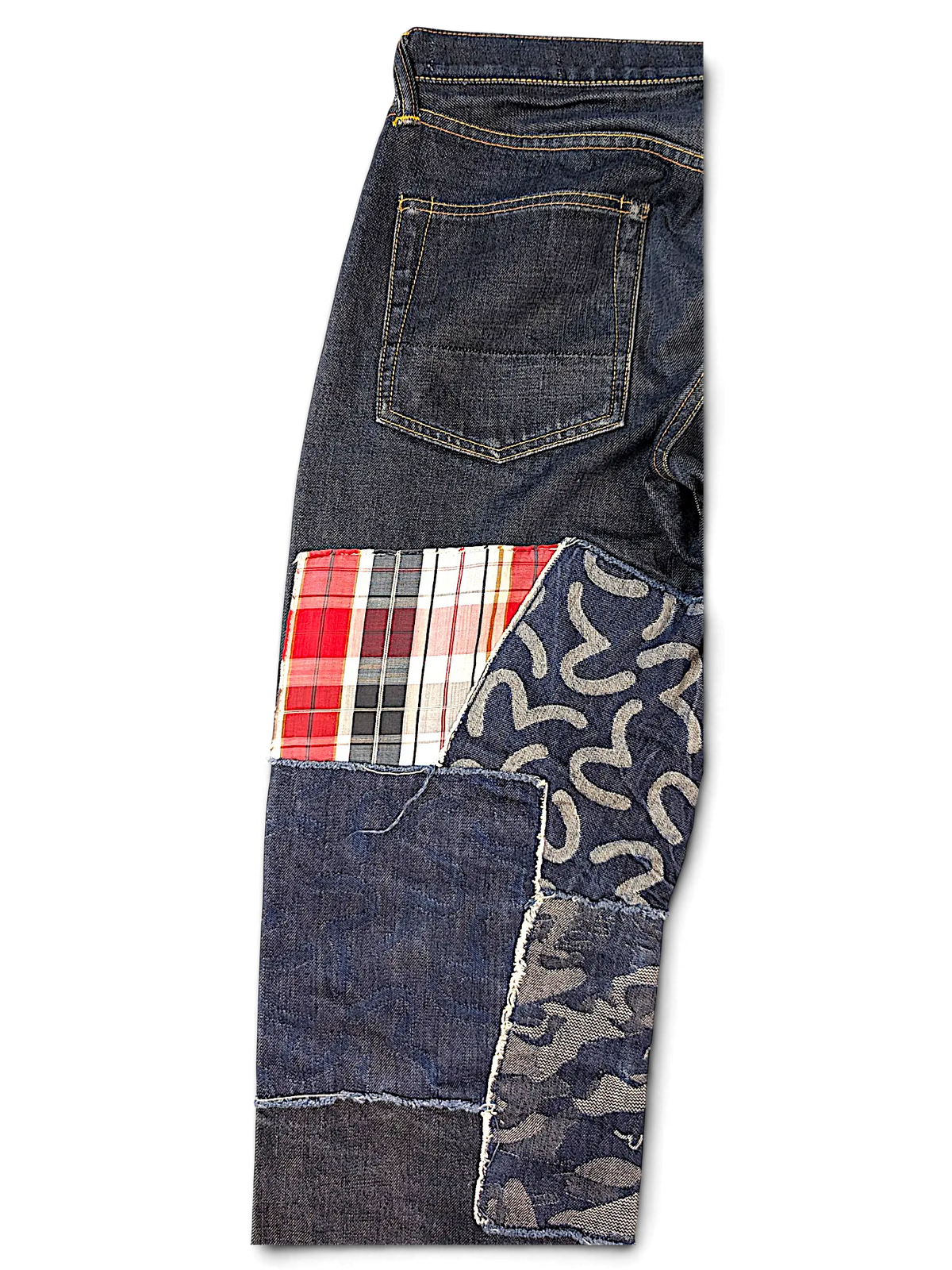 JAKE & IPI Evisu one of one jeans featuring dark denim with patchwork details in plaid, camo, and logo patterns.