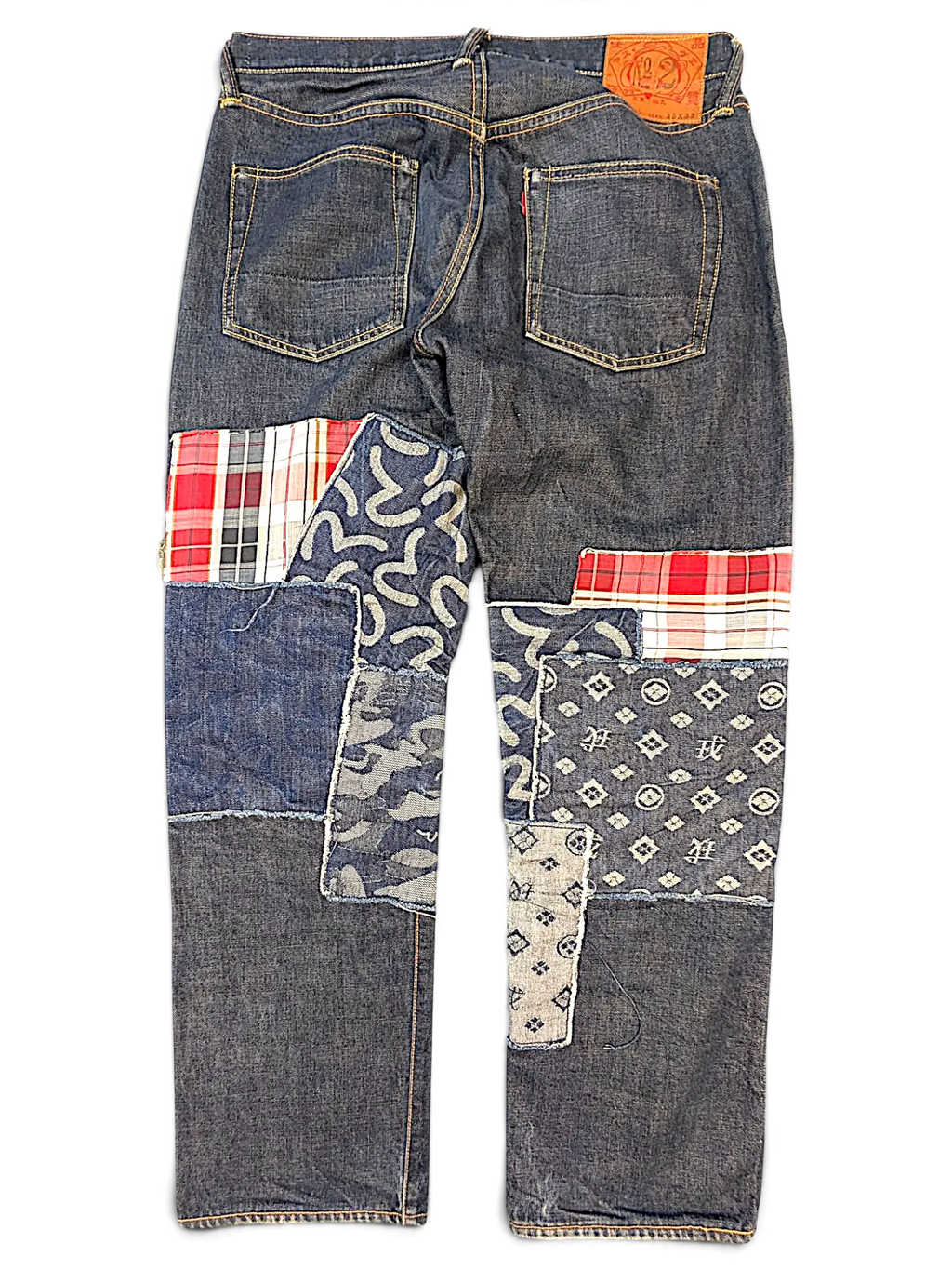 JAKE & IPI Evisu one of one jeans featuring dark denim with mixed fabric patchwork, plaid, and patterned denim panels.