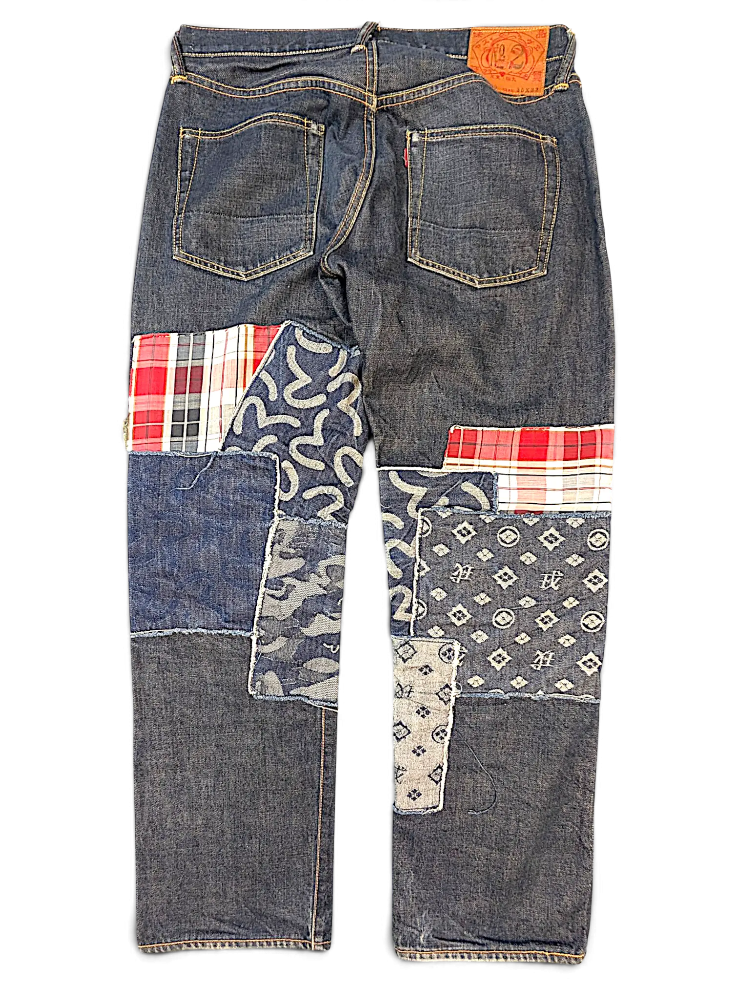 JAKE & IPI Evisu one of one jeans featuring dark denim with mixed fabric patchwork, plaid, and patterned denim panels.
