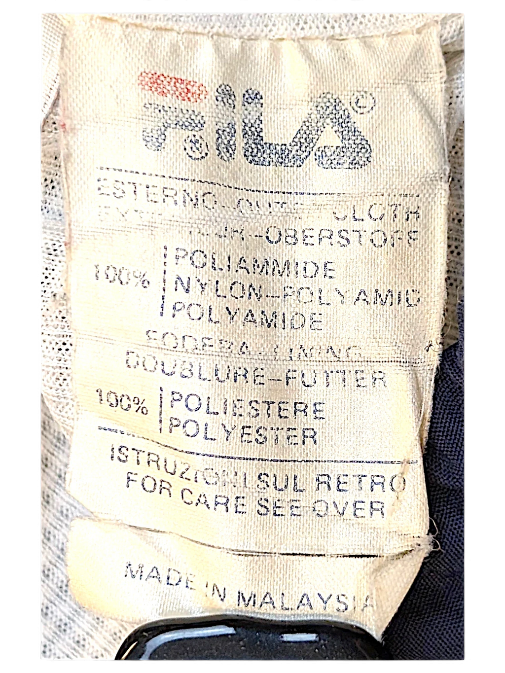 JAKE & IPI Fila track pants care label showing 100 percent nylon outer and 100 percent polyester lining