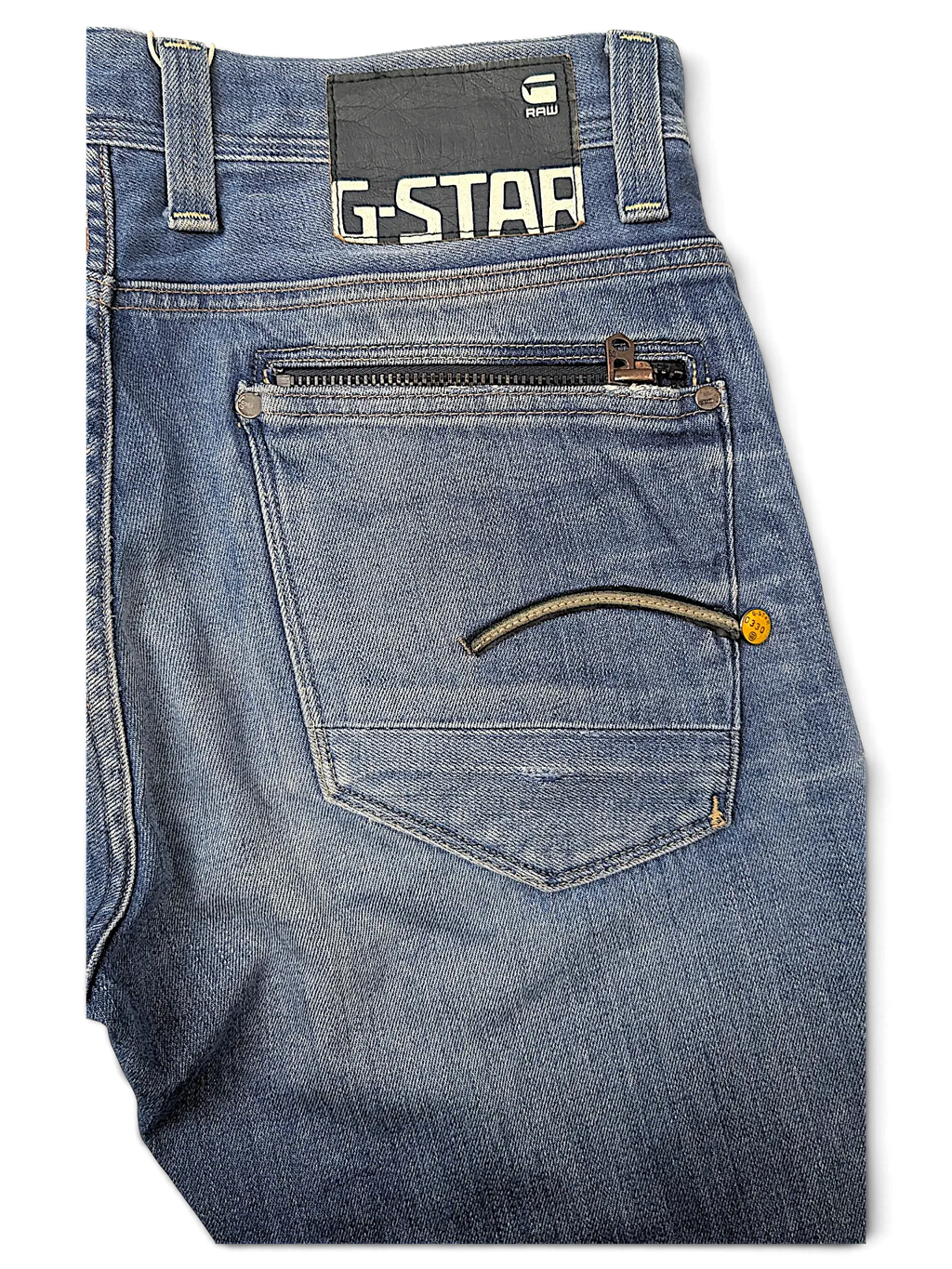 JAKE & IPI G-Star jeans in blue denim featuring a back pocket with a zipper and signature logo patch.