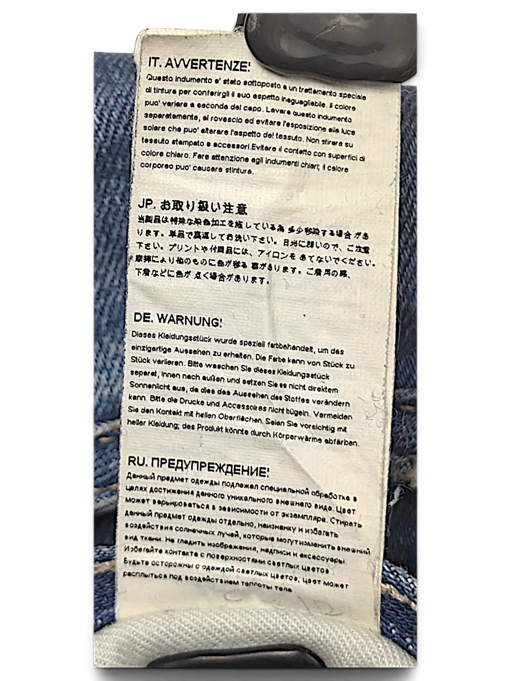 JAKE & IPI G-Star jeans care label with multi-language washing instructions attached to blue denim fabric