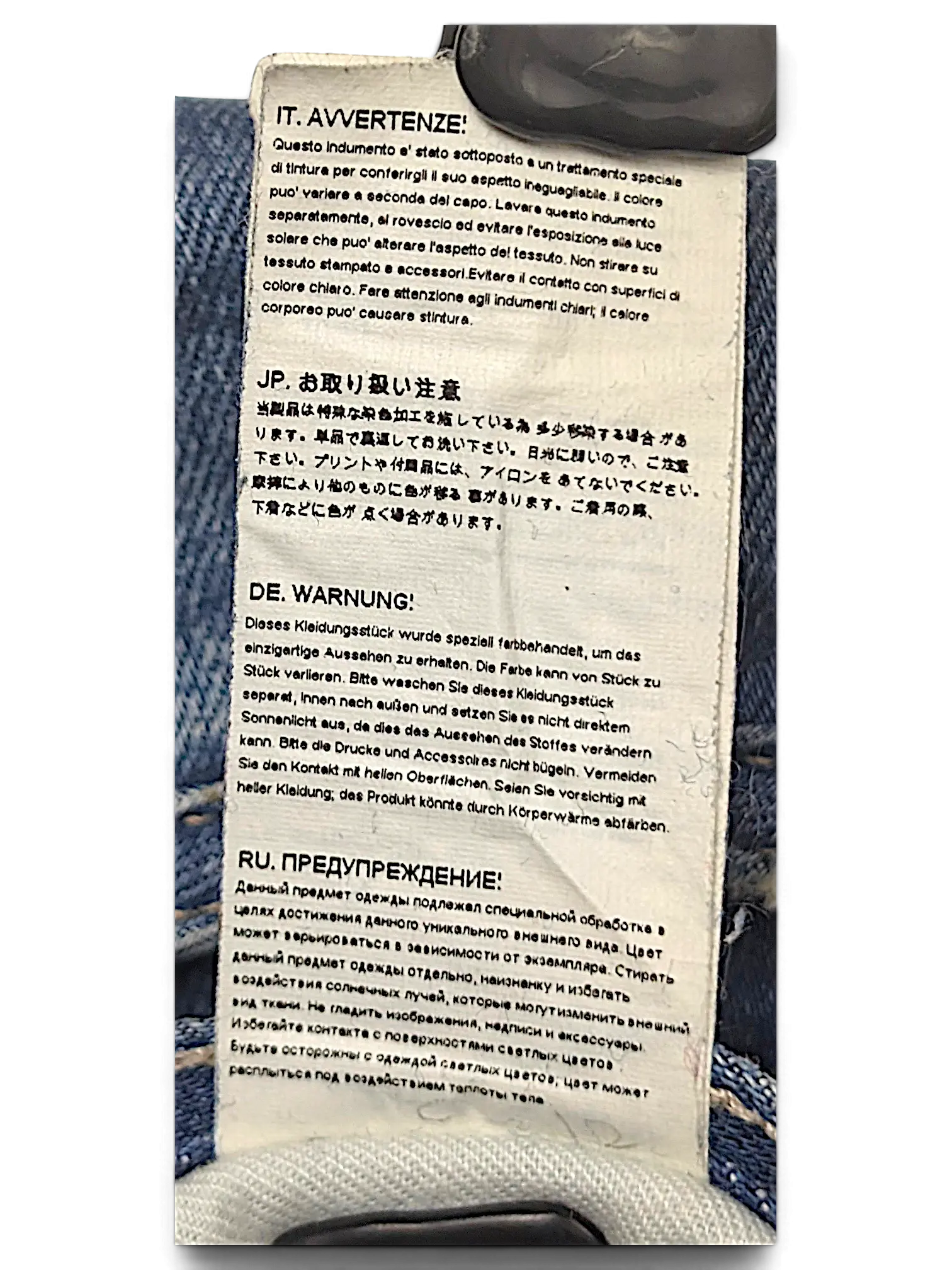 JAKE & IPI G-Star jeans care label with multi-language washing instructions attached to blue denim fabric