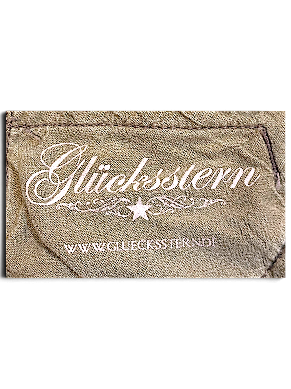 JAKE & IPI Glücksstern brand label on light brown fabric with a distressed, worn-in texture.
