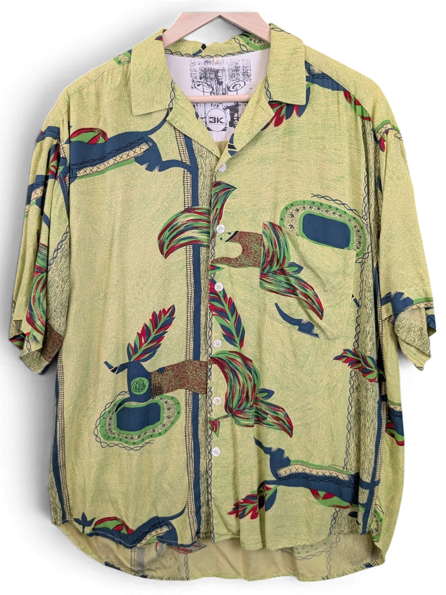 JAKE & IPI green Hawaiian shirt with a textured fabric, button-down front, and abstract tropical leaf patterns.