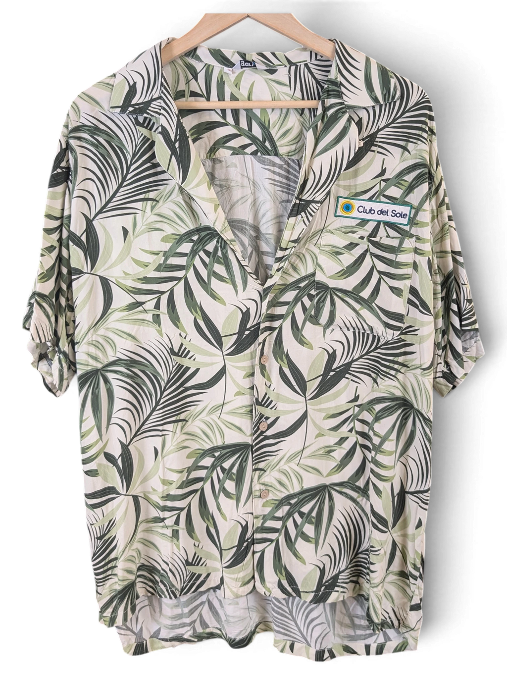 JAKE & IPI Gary's Hawaiian shirt in cream and green palm leaf print with a Club del Sole patch, missing one button.