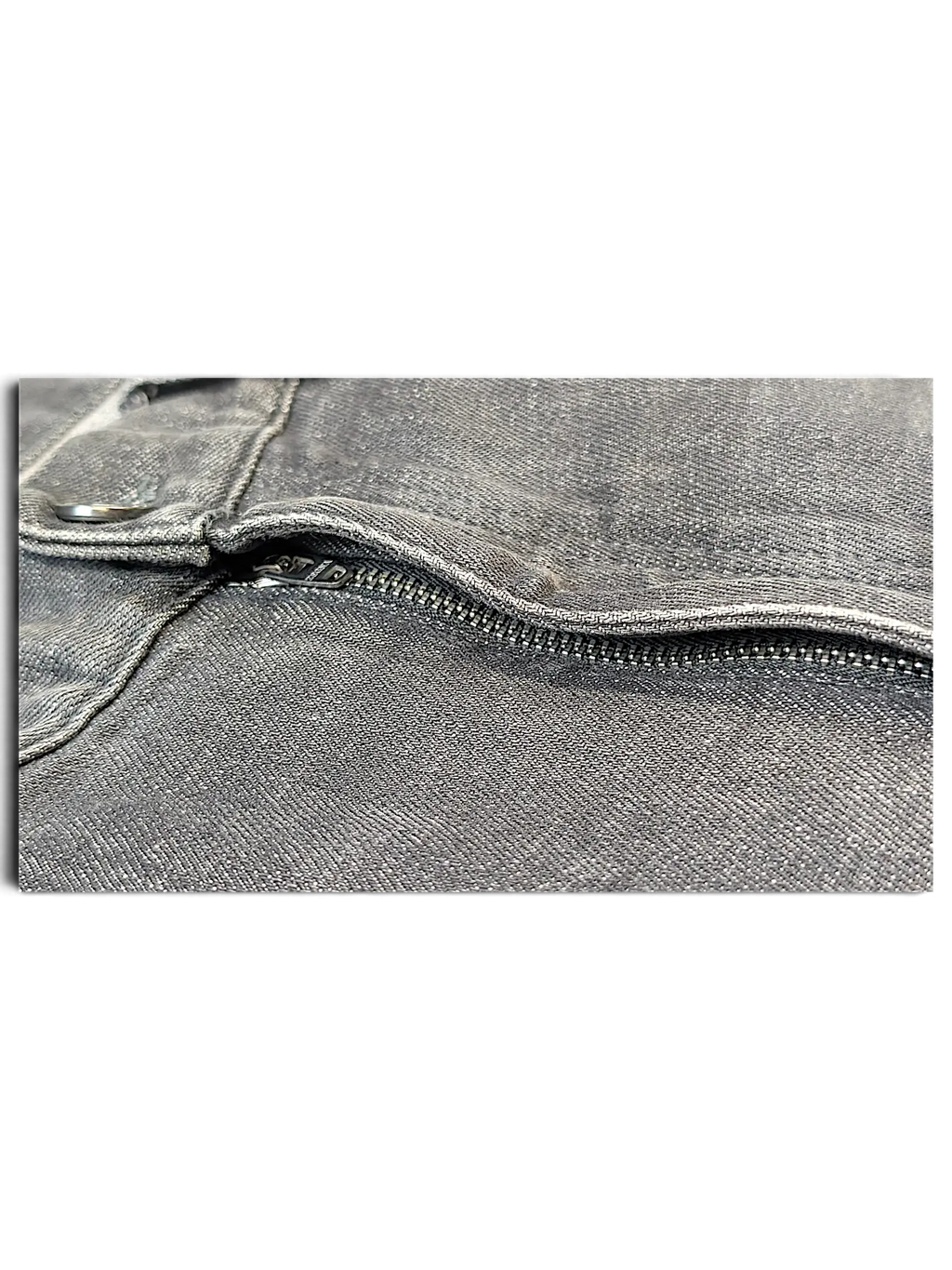Close-up of the grey denim fabric and metal zipper detail on JAKE & IPI IBE Zegna jeans.