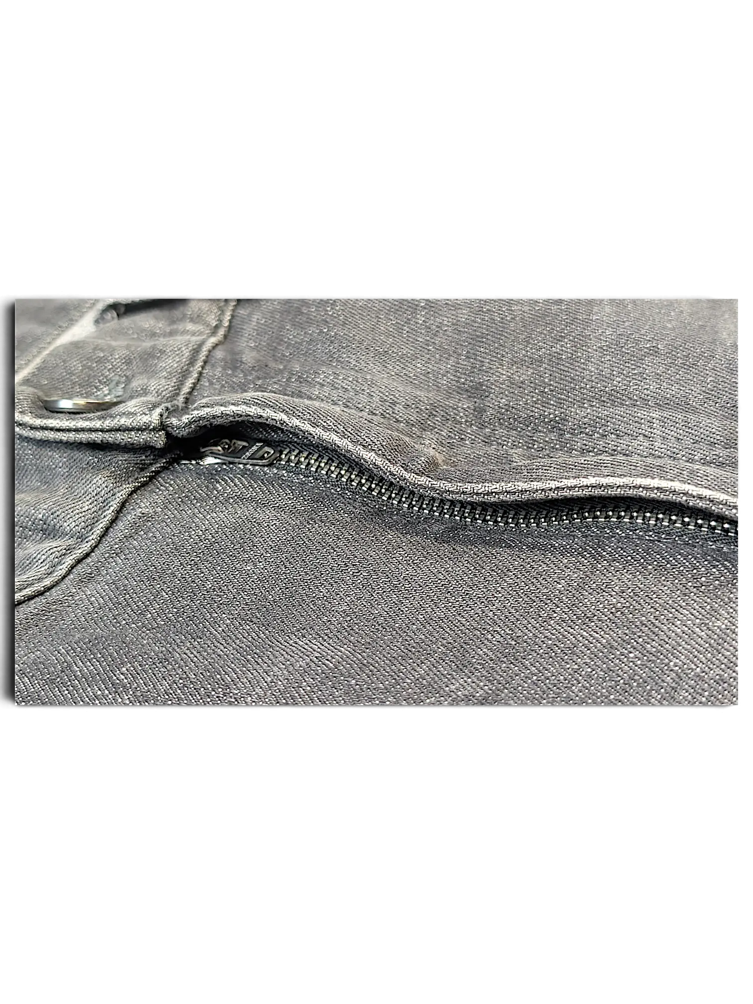 Close-up of the grey denim fabric and metal zipper detail on JAKE & IPI IBE Zegna jeans.