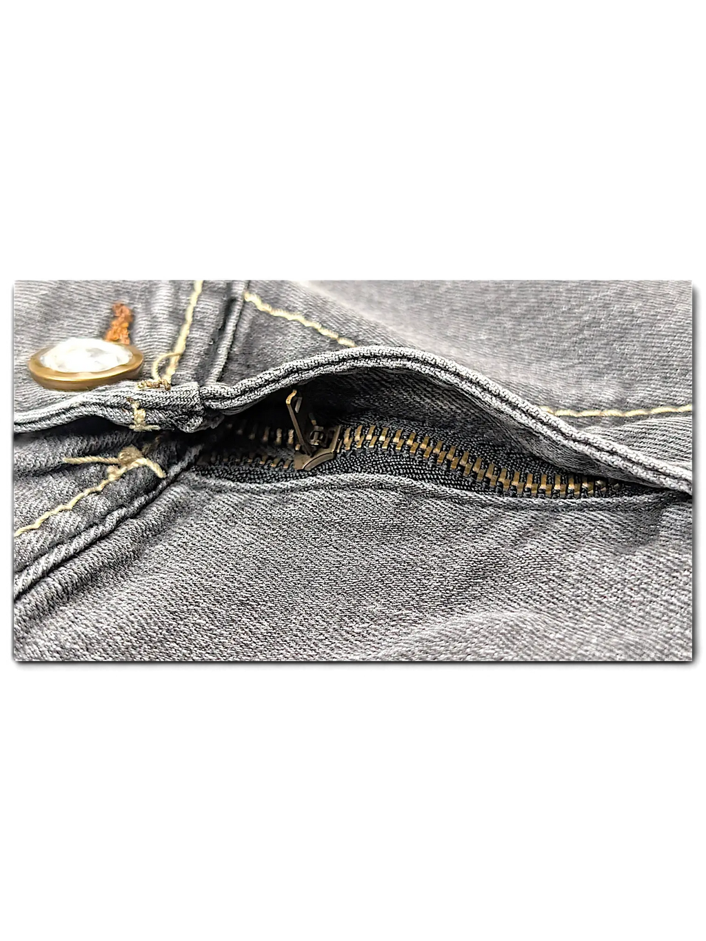 Close-up of JAKE & IPI SP Classic Y2K Jeans 20 featuring grey denim fabric, a metal zipper, and contrast stitching.