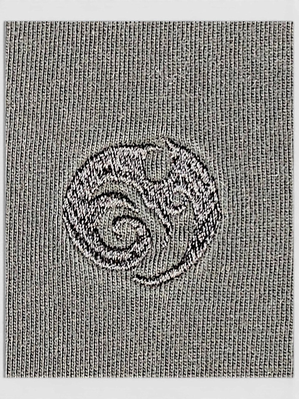 Close-up of the JAKE & IPI IBE Mori Velle long-sleeve shirt featuring a textured grey knit and embroidered logo.