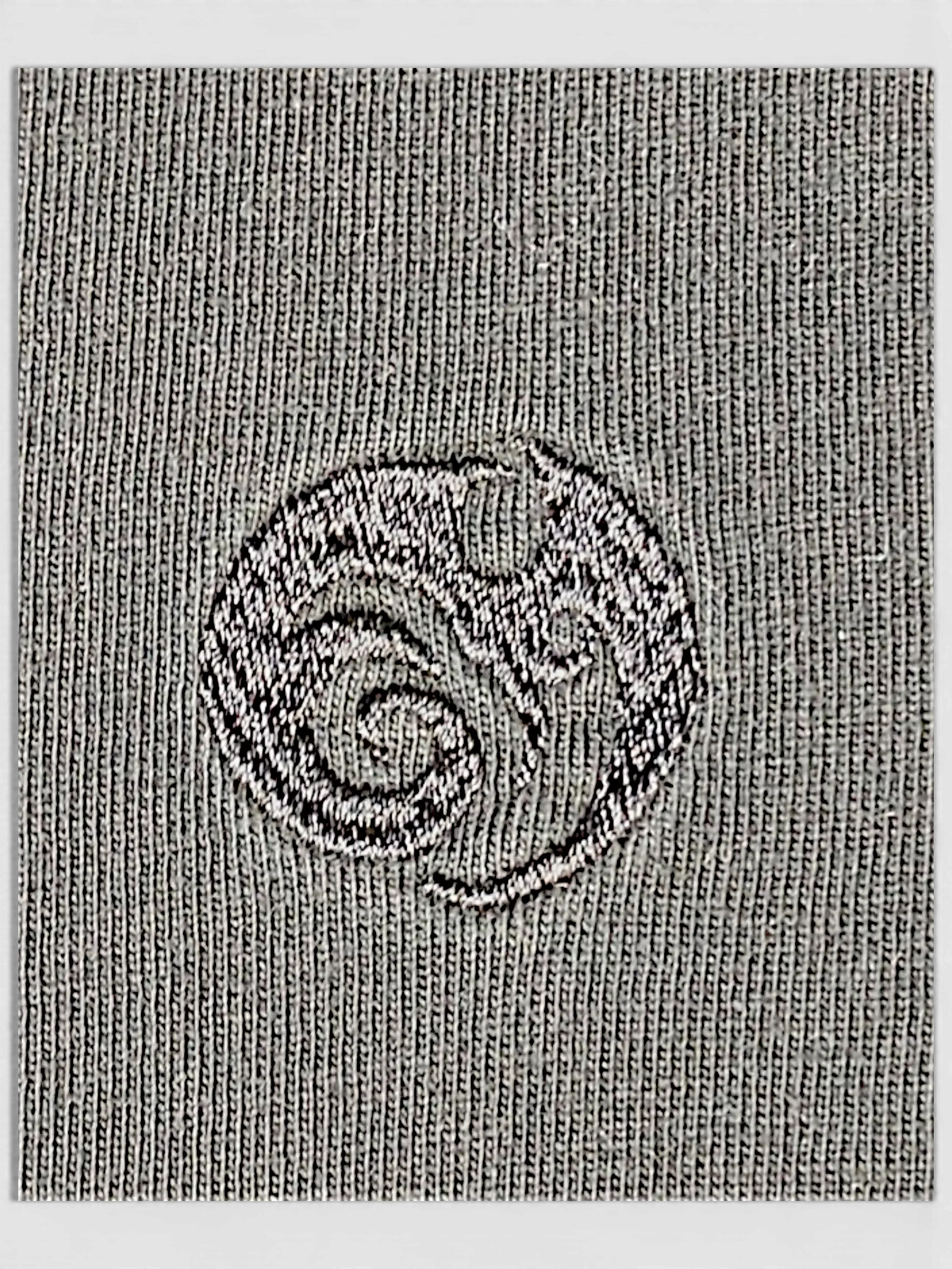 Close-up of the JAKE & IPI IBE Mori Velle long-sleeve shirt featuring a textured grey knit and embroidered logo.