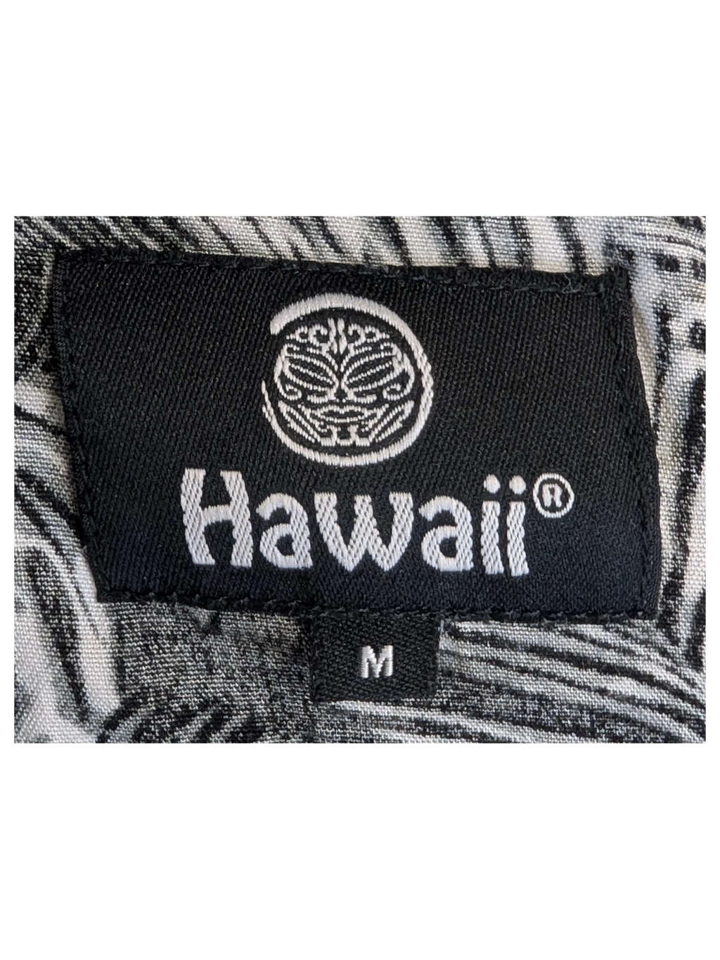 JAKE & IPI Hawaii Hawaiian shirt featuring a black and white tropical leaf print pattern on a fabric neck label