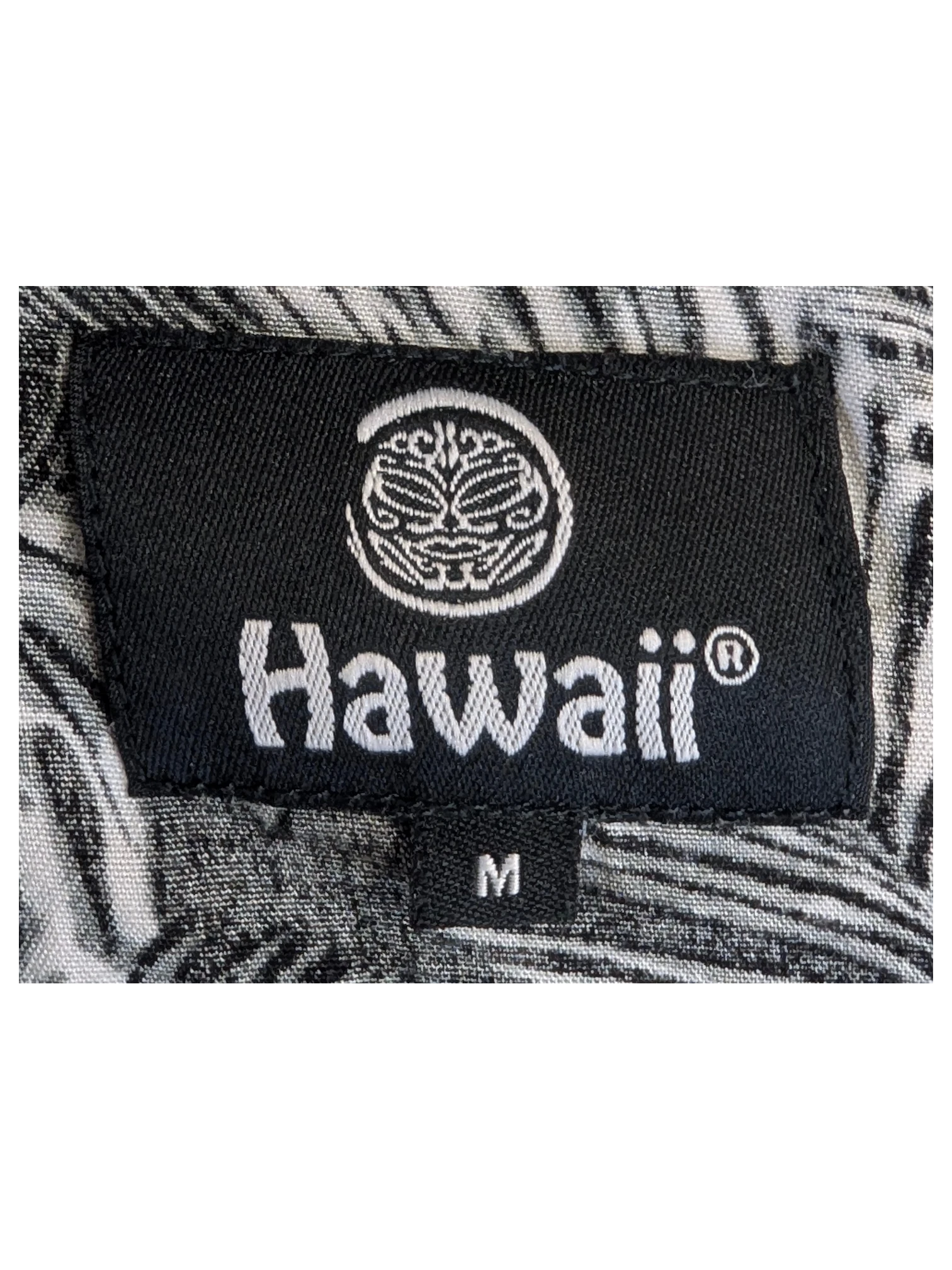 JAKE & IPI Hawaii Hawaiian shirt featuring a black and white tropical leaf print pattern on a fabric neck label