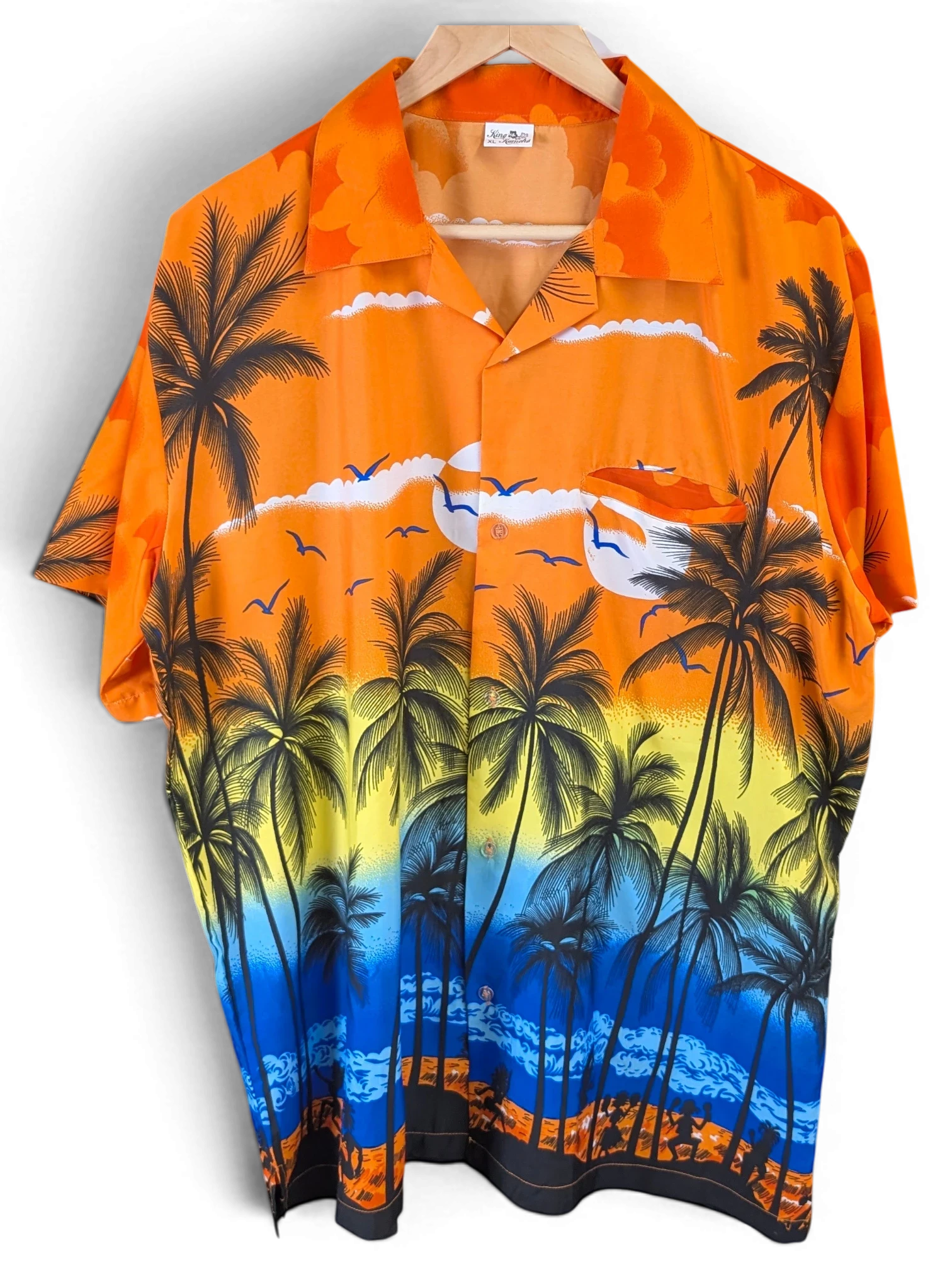 JAKE & IPI King Kahema Hawaiian shirt featuring a vibrant orange, yellow, and blue sunset palm tree beach print.