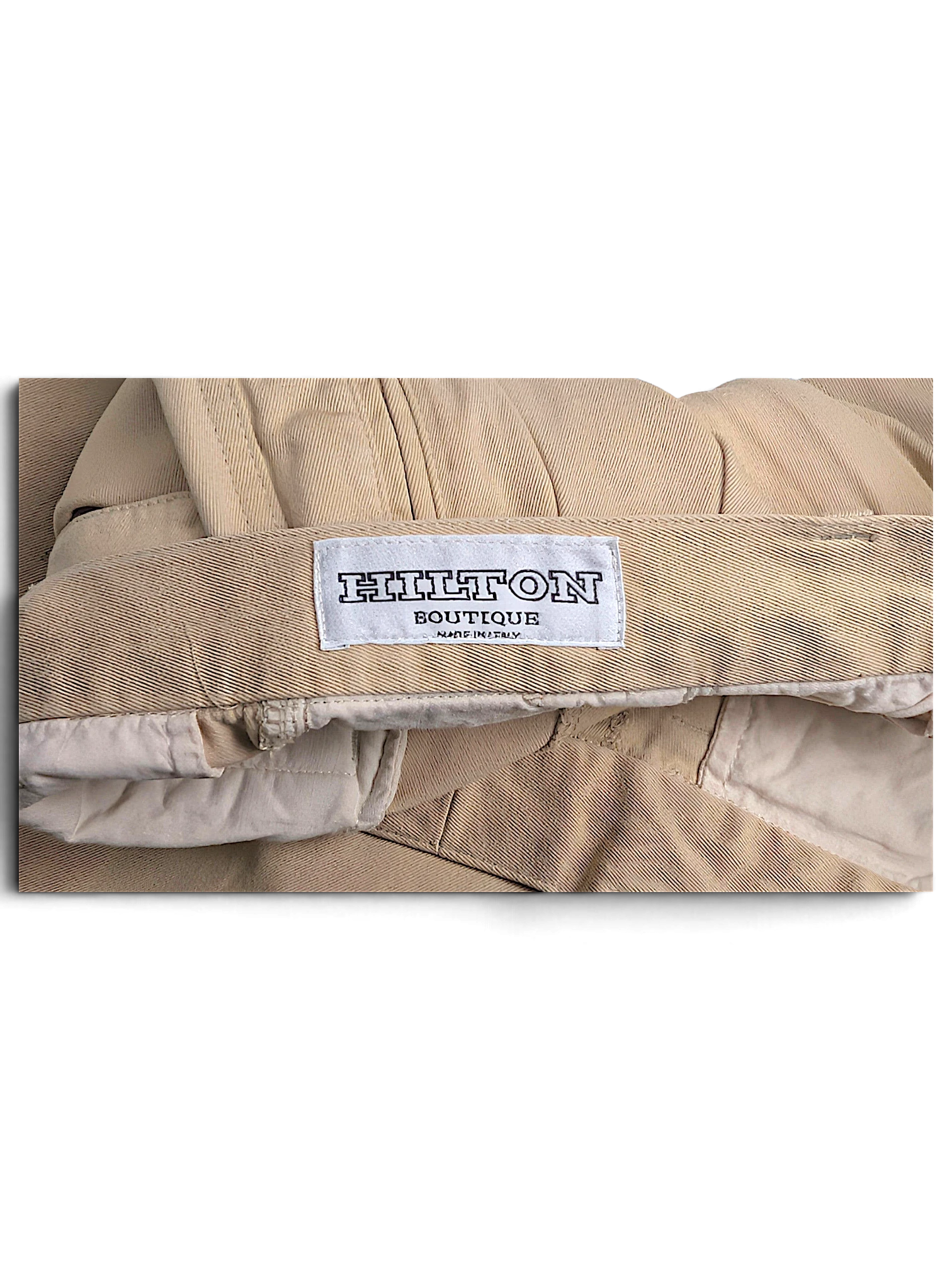 JAKE & IPI Hilton Boutique beige pleated trousers featuring a tailored waistband and interior brand label